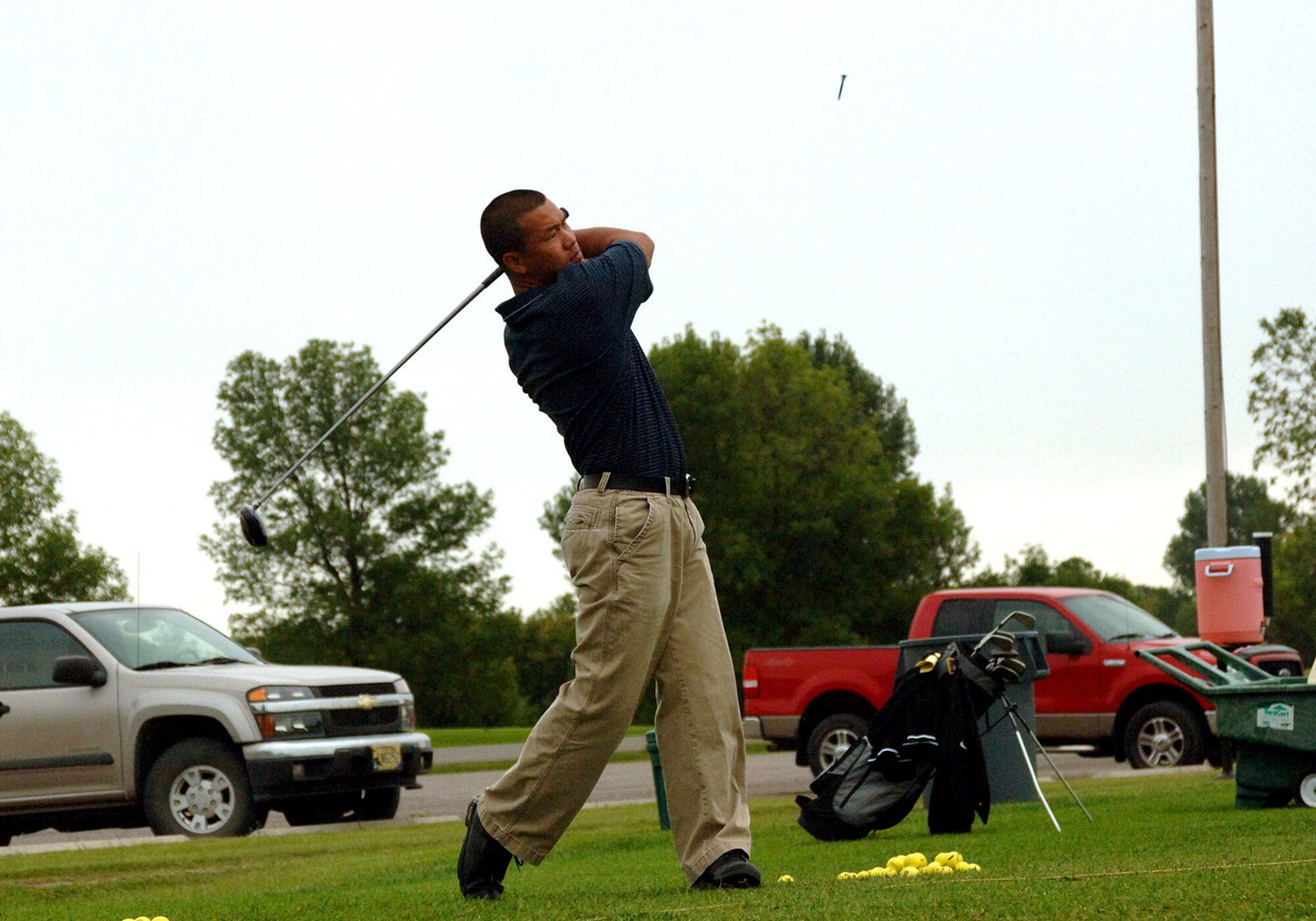 GRAND FORKS AIR FORCE BASE, N.D. -- A tee falling back to earth is all that remains after a drive by Maj. Steven Dougherty, 319th Air Refueling Wing Inspector General office, during practice at the driving range prior to the annual Grand Forks Military Appreciation Committee golf tournament. Teams comprised of both military and civilian leaders, spent the morning of Aug. 6 in friendly competition including longest drive, longest putt and closest to the hole contests. (U.S. Air Force photo/Senior Airman SerMae Lampkin)