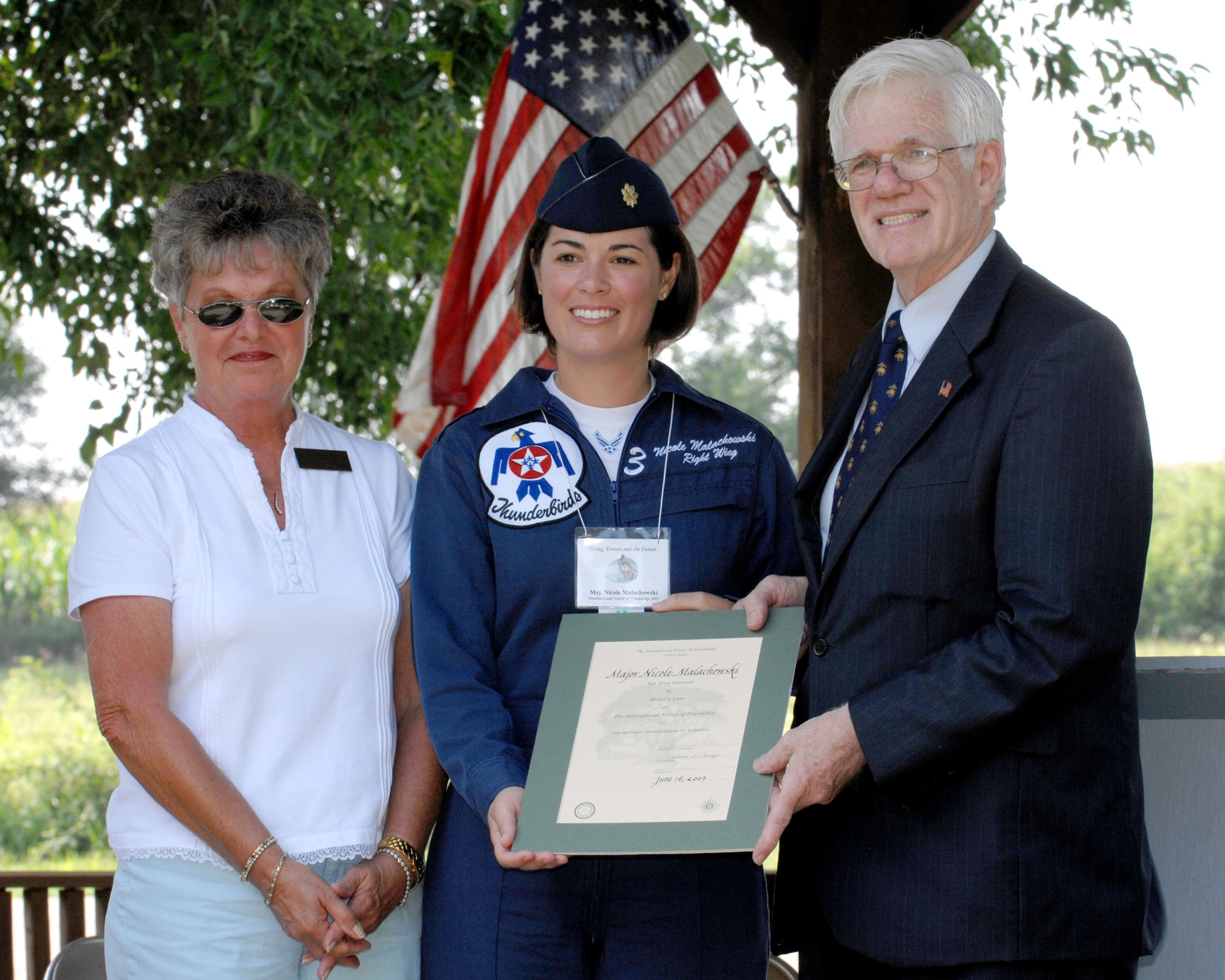 Dr. Linton Wells (right), co-founder of the International Forest of Friends, awards Maj. Nicole Malachowski an induction certificate into the Forest Aug 4 at Atchison, Kan. She is first female pilot with the Thunderbirds. (U.S. Air Force photo/Airman 1st Class Cory G. Todd) 
