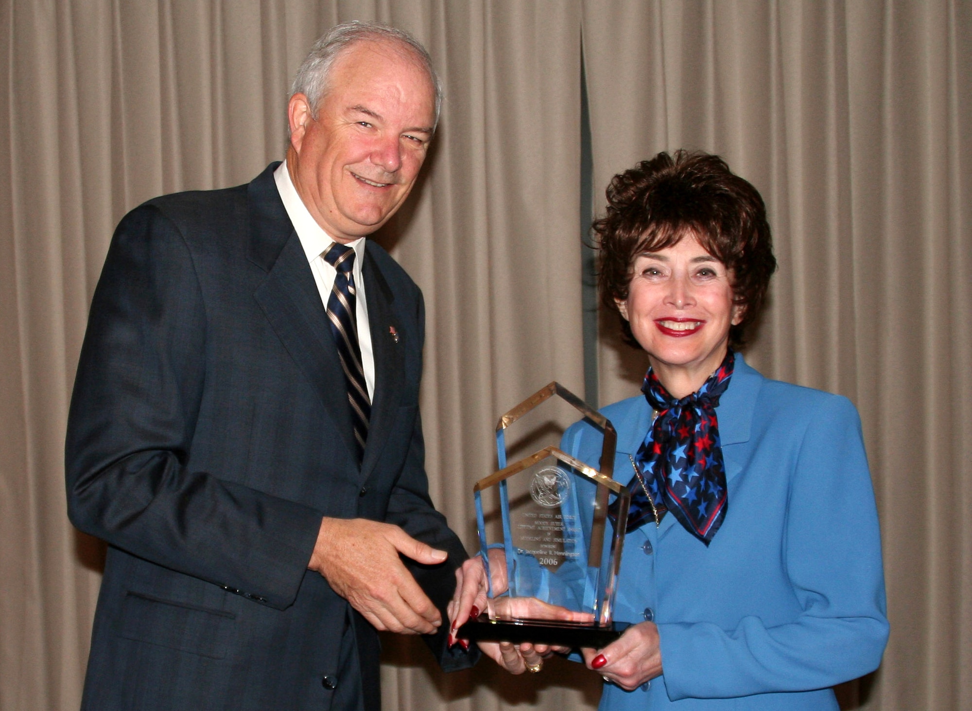 Secretary of the Air Force Michael W. Wynne presents the Air Force Modeling and Simulation Moody Suter Lifetime Achievement Award to Dr. Jacqueline R. Henningsen, director for Air Force studies and analyses, assessments and lessons learned. (U.S. Air Force photo/Sandra Guthrie)