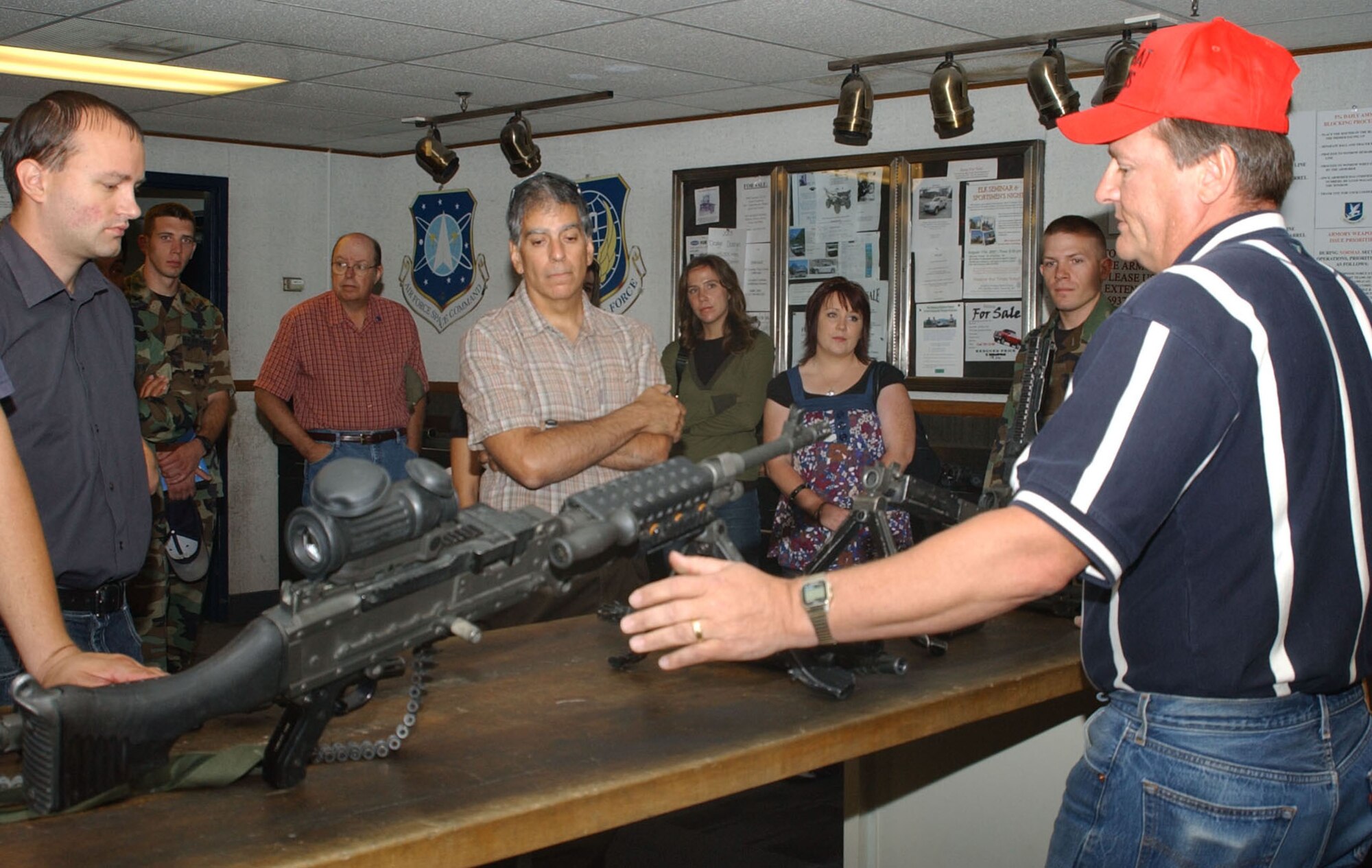 Reporters and editors with the Great Falls Tribune take a moment to learn about the M240B machine gun from Jeff Bragg, 341st Security Forces Support Squadron combat arms instructor, during a base tour Aug. 8. The Tribune staff were given a mission briefing from wing leadership, learned about a missileer's day-to-day responsibilities and also toured a missile maintenance facility.  (U.S. Air Force photo/Senior Airman Eydie Sakura).