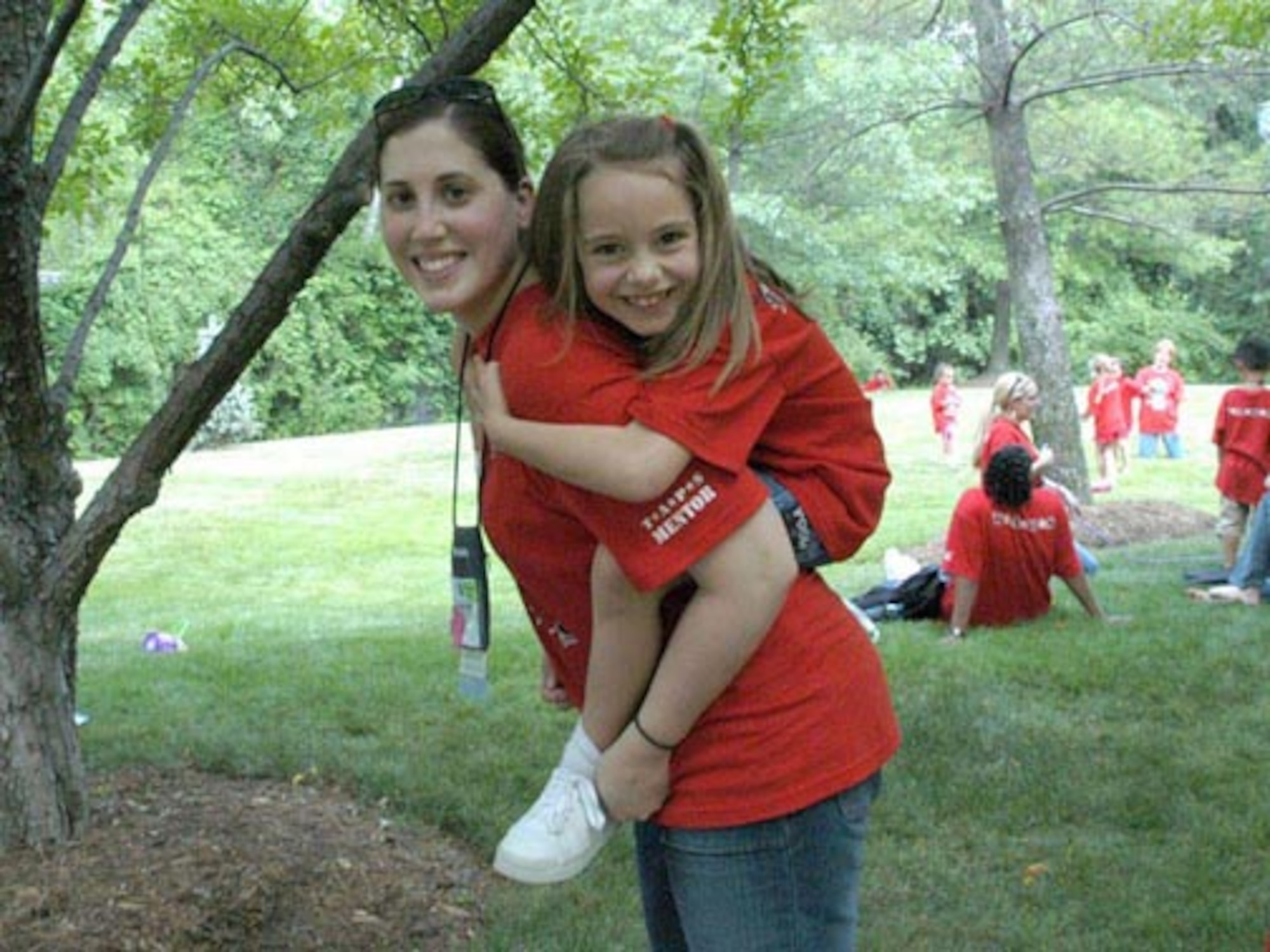 Technical Sergeant Samantha J. Clarke, 119th Services Flight, gives Laura Hilton a piggy-back ride at TAPS Good Grief Camp.  One goal of the camp is to do something with the children that they can no longer do with the lost loved one.  Laura's father, U.S. Navy LT. Lawrence Hilton, died July 22, 2004.  (Courtesy photo/William A. Pratt)