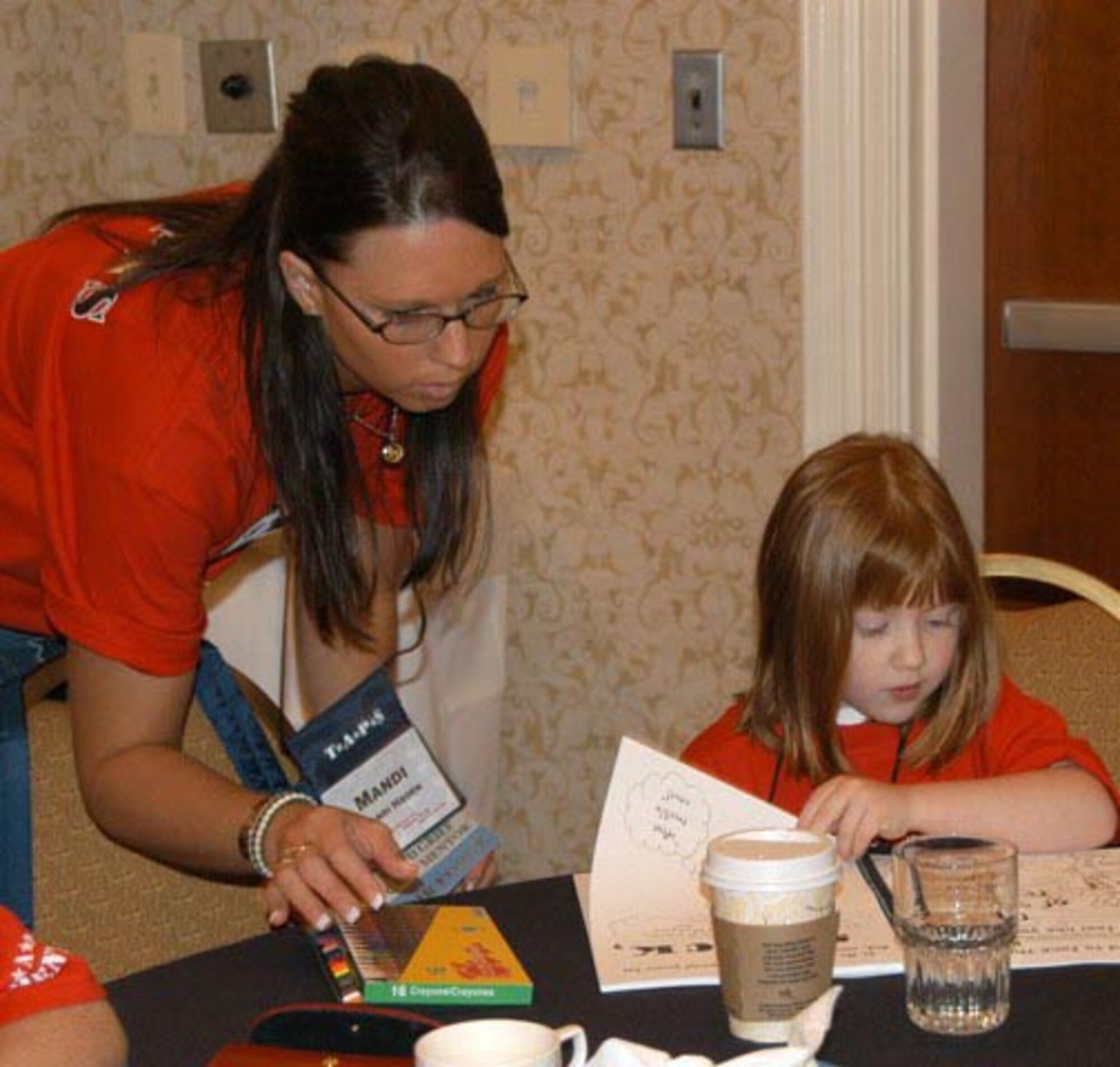 Senior Airman Mandi R. Hagen, 119th Services Flight, works on a craft project with Adela Storey as part of TAPS Good Grief Camp.  Adela's father, Staff Sgt. Clint J. Storey, was killed in action August 4, 2006 in Iraq.  (Courtesy photo/William A. Pratt)