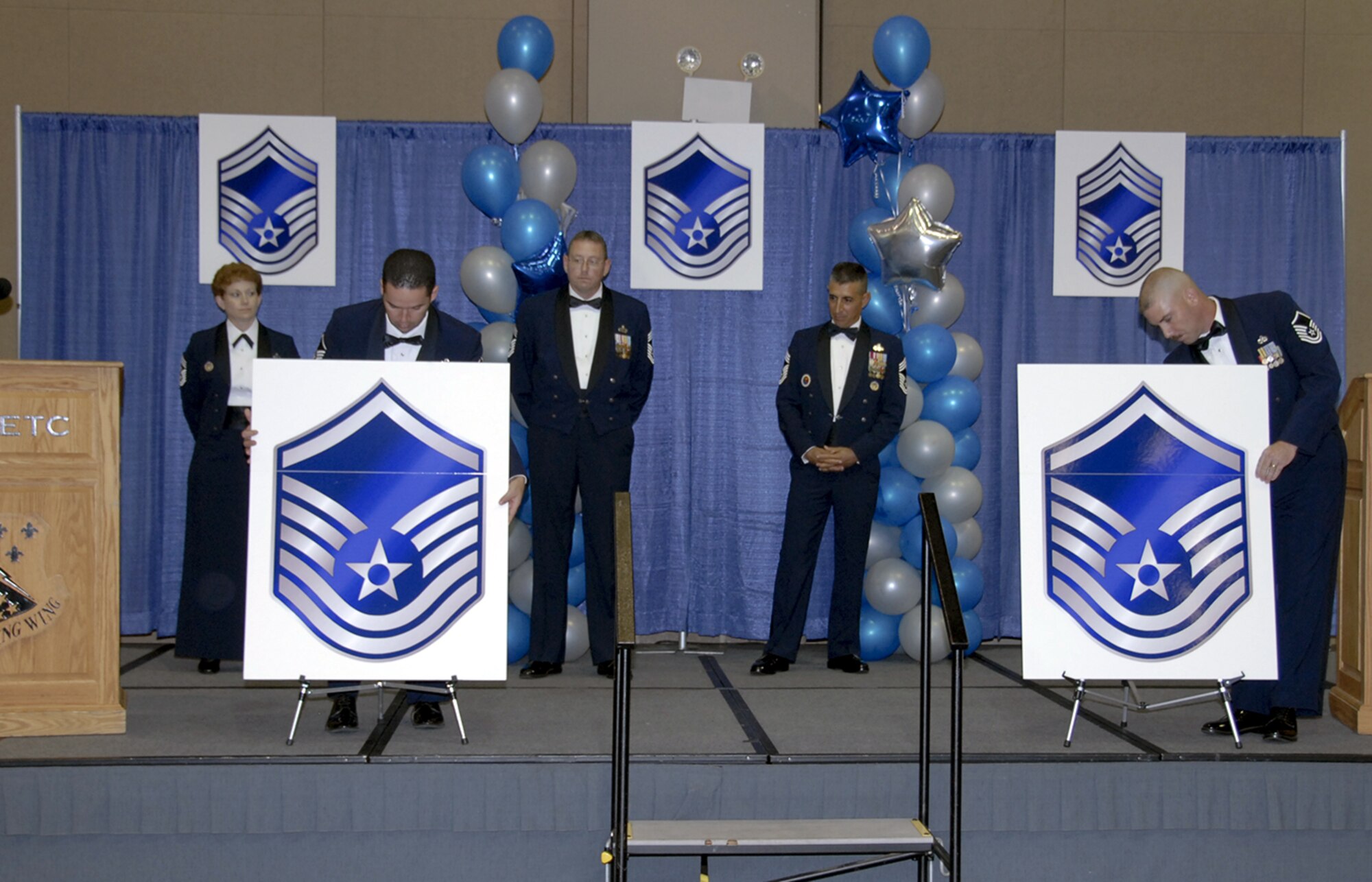 Master Sgt. Scott Croper and Master Sgt. Edward Carballo, "raise the roof" on a set of tech sergeant stripes at the Senior NCO Induction Ceremony Aug. 3 at the Multi-Purpose Events Center in Wichita Falls. (U.S. Air Force photo/Sandy Wassenmiller)