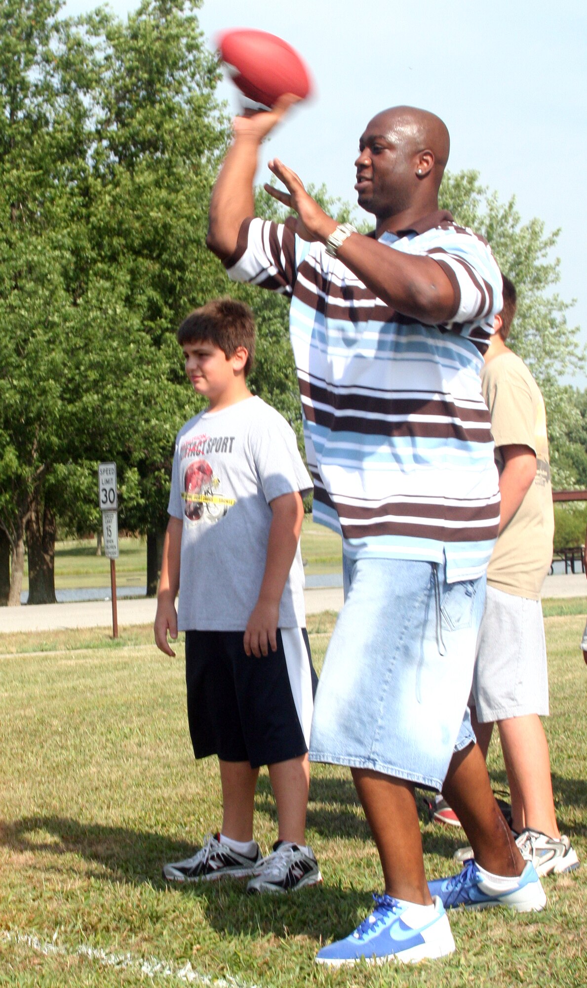 WHITEMAN AIR FORCE BASE, Mo. – Boo Williams throws down field during the youth football clinic at the base soccer field Aug. 8. He plays wide receiver for the Kansas City Brigade. (U.S. Air Force photo/Airman 1st Class Stephen Linch)

