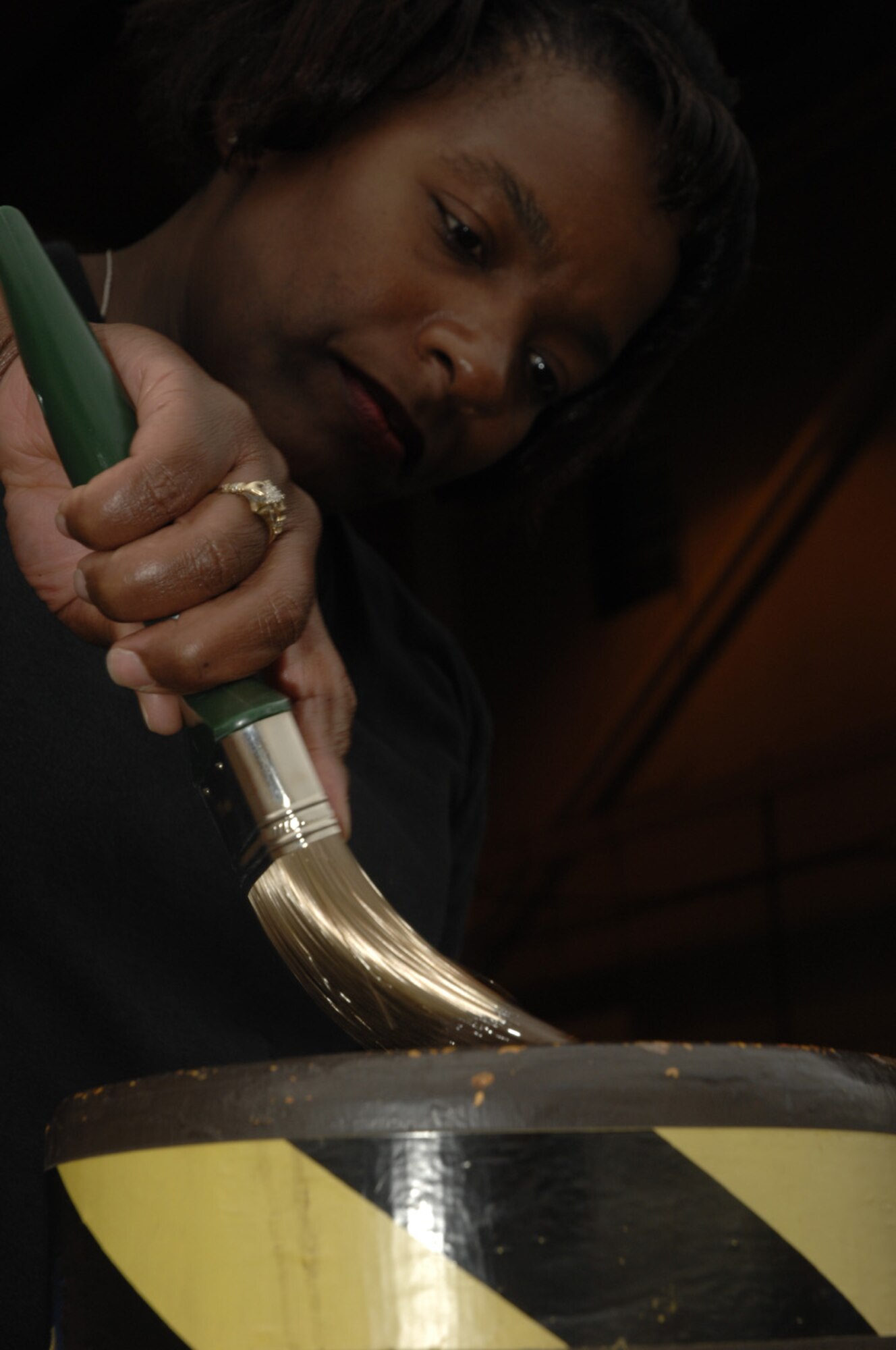 Staff Sgt Bobbie Workman, 48th Civil Engineering Squadron, RAF Lakenheath, repaints a bollard. Sergeant Workman, a Structural Craftsman, is capable of carpentry, masonry, metallurgy, welding, sheet metal, roofing and locksmith. (U.S. Air Force photo by Airman 1st Class Jessica Snow)