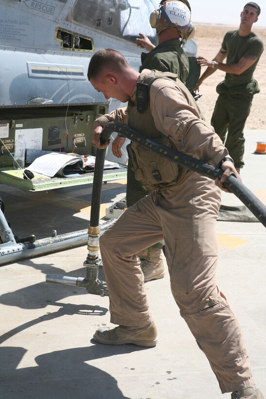 AL ASAD, Iraq- Lance Cpl. Andrew Krebs, a motor transportation refueler from Marine Wing Support Squadron 271, pulls the fuel nozzle out from his truck to refuel an AH-1W Cobra, Aug. 10.  After inserting the nozzle, the Marine grounds the truck to the bird cutting out static electricity and opens the fuel valves to begin fueling.