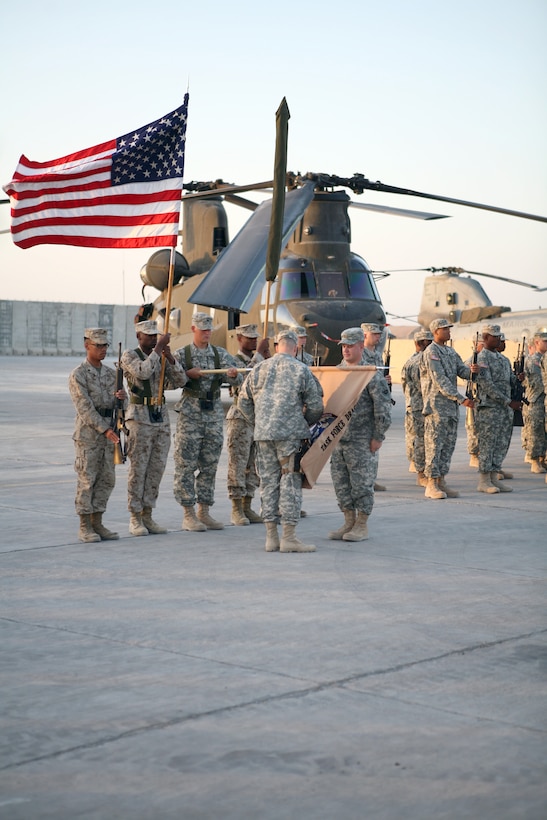 AL TAQADDUM, Iraq - Army Maj. James Dimon, the commanding officer of Task Force Dragon, uncases the task force colors during the transfer of authority ceremony with Marine Medium Helicopter Squadron 262, Aug. 10.