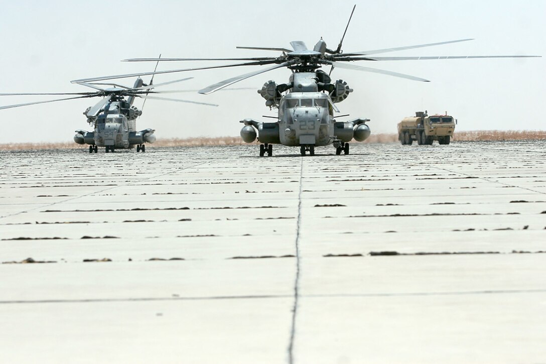 COMBAT OUTPOST RAWAH, IRAQ -- During long operations the combat trains of Task Force Highlander, Regimental Combat Team 2, rely on air support from the CH-53E “Super Stallions” of Marine Heavy Helicopter Squadron 466 to re-stock their fuel supply. Because of the support from the helicopter squadron, also known as the “Wolfpack,” and cooperation between Army and Marine Corps logistics, Task Force Highlander and its supporting units continue to complete successful missions throughout the western Al Anbar province. Official Marine Corps Photo By Cpl. Ryan C. Heiser.