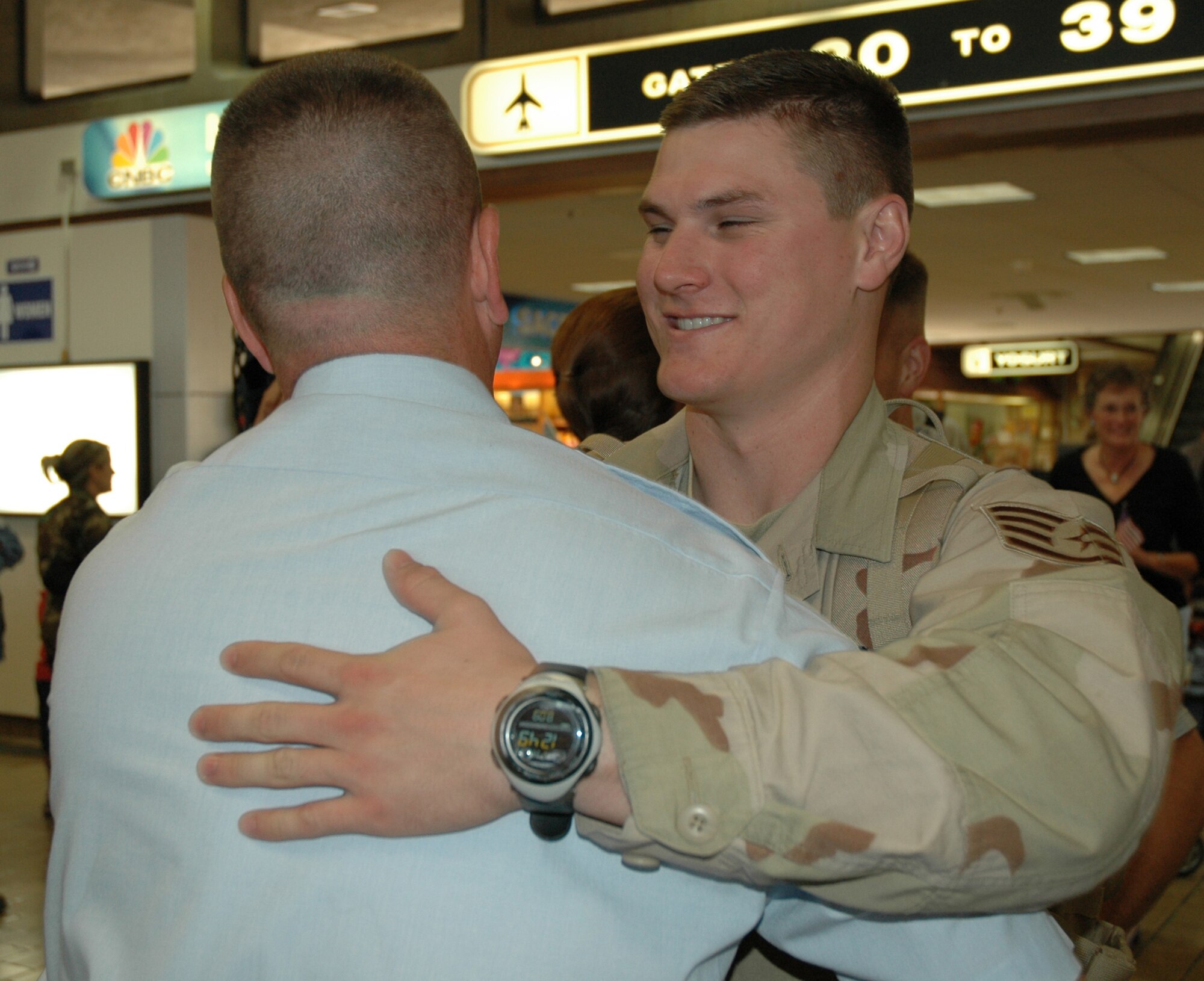 Staff Sgt. Doug Brock, a Reservist with the 940th Logistics Readiness Squadron, gets a welcoming hug on his return home from a 179-day tour of duty to Manas Air Base, Kyrgyzstan, A police officer in Fremont, Calif., he was on his second deployment in support of the Global War on Terror. (US Air Force photo/Master Sgt Ellen L Hatfield)