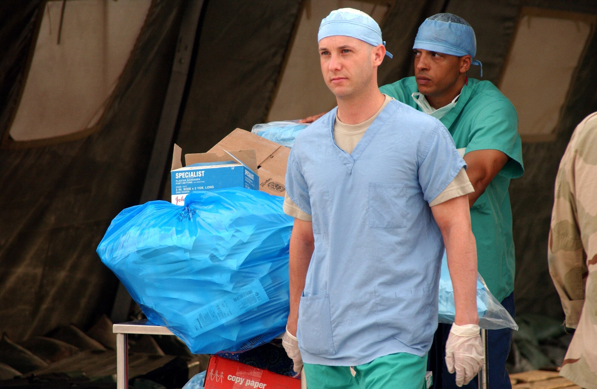 Senior Airman James Ray and Tech. Sgt. Christopher Harwell move operating room equipment from the 332nd Expeditionary Medical Group's Air Force Theater Hospital's tent facility to its newly upgraded, pre-engineered facility at Balad Air Base, Iraq, Aug. 3. Starting at 4 a.m., about 150 base volunteers and 380 332nd EMDG Airmen moved patients and equipment to the new facility. Airman Ray and Sergeant Harwell are surgical technicians assigned to the 332nd EMDG. (U.S. Air Force photo/1st Lt. Shannon Collins) 