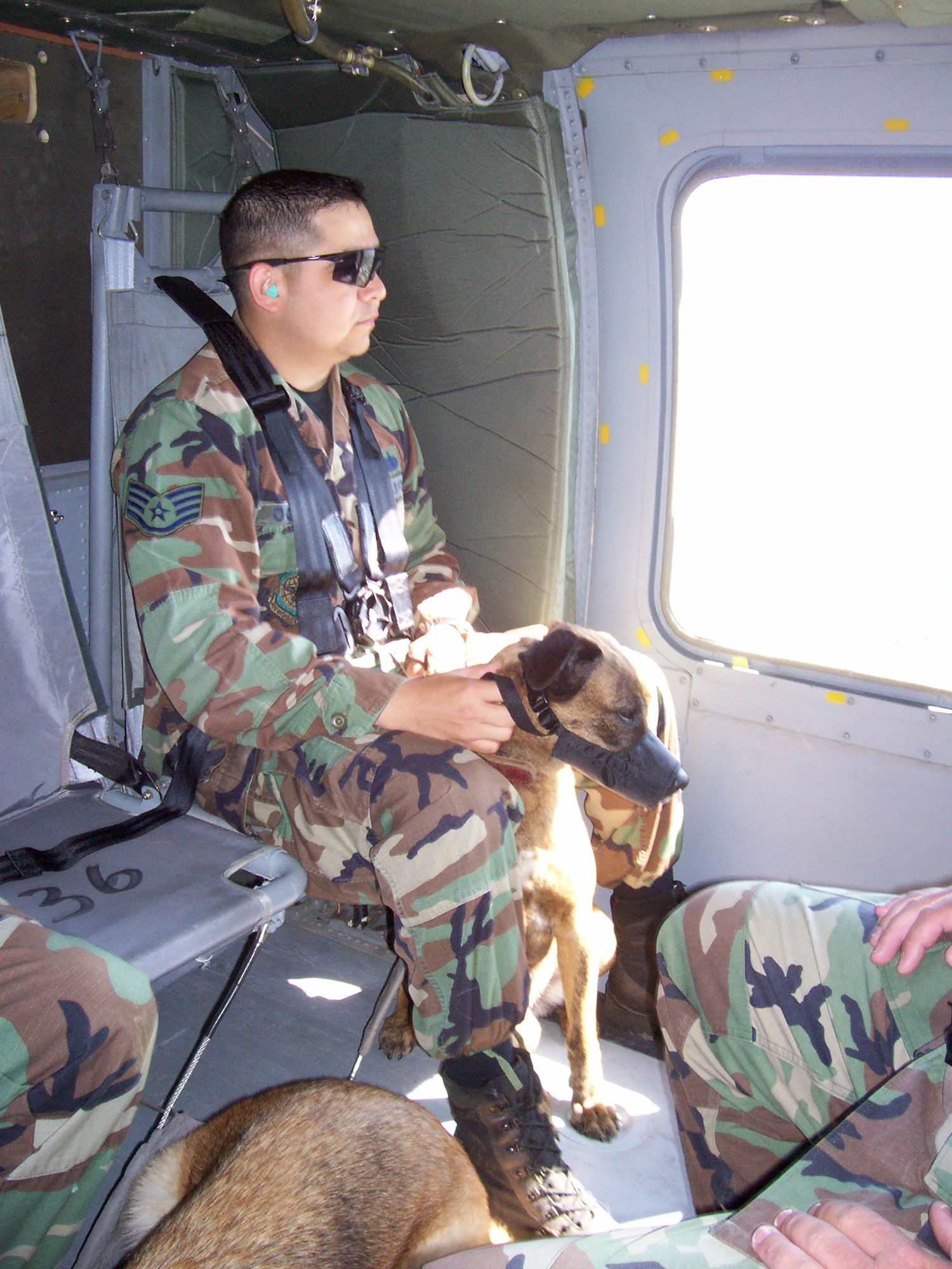 Staff Sgt. Mark Ochoa, 319th Security Forces Squadron, Grand Forks Air Force Base, N.D., sits with his military working dog, Borek, during a Blackhawk flight to prepare for transportation between forward operating locations when deployed to the Middle East. (U.S. Air Force Photo/Tech. Sgt. Jeffrey Dean)