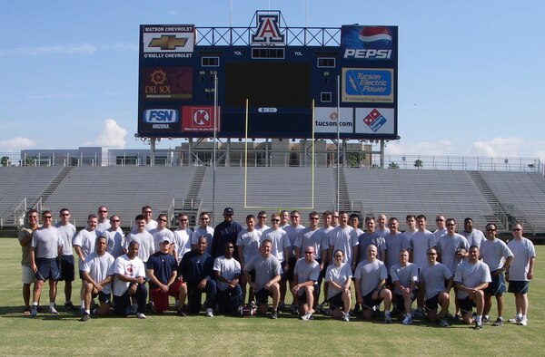 Members of the 55th Rescue Squadron here pose with University of Arizona football coaches at UA's Arizona Stadium. The coaches hosted the Airmen for an hour-long football-style physical training session July 27. (U.S. Air Force photo/Maj. Kyle Cowherd) 