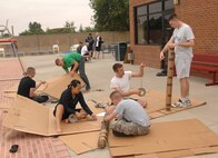 MINOT AIR FORCE BASE, N.D. -- Airmen work together to construct cardboard boats during the Sports Day build-a-boat contest here Aug 10. Sports day is a day set aside for units to participate as a group in various sporting activities. Participating units were required to build a boat using only duct tape and cardboard, and race across the base outdoor pool. (U.S. Air Force photo by Airman 1st Class Cassandra Jones)