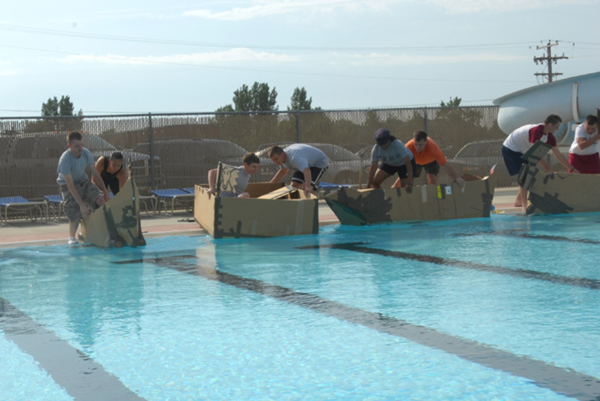 MINOT AIR FORCE BASE, N.D. -- Airmen prepare to race their boats across the base outdoor pool here during the Sports Day build-a-boat contest Aug 10. Sports day is a day set aside for units to participate as a group in various sporting activities. Participating units were required to build a boat using only duct tape and cardboard, and race across the base outdoor pool. (U.S. Air Force photo by Airman 1st Class Sharida Bishop)