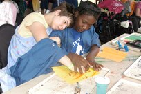 Eighteen-year-old camper Brittany enjoys a tender moment with Camp CAMP counselor Deshaya Robinson during an arts and crafts activity July 31 at Camp CAMP near Center Point, Texas. The Children's Association for Maximum Potential has offices at Lackland AFB. (USAF photo by Lilly Flores-Janecek)                                
