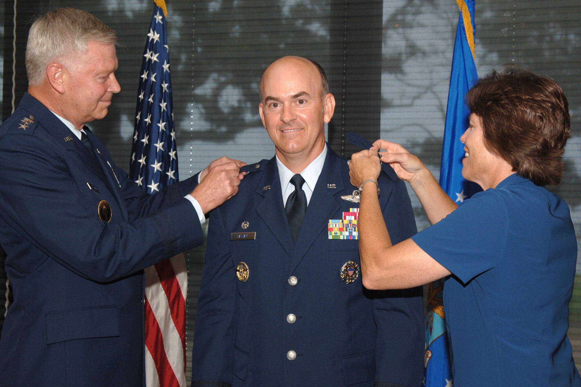 Brig. Gen. Michael Callan (center), Air Force Special Operations Forces commander, receives his first stars from Gen. Charles Holland (left), former U.S. Special Operations Command commander, and his wife (right), Ann Callan, during a promotion ceremony held Aug. 10 at Hurlburt Field, Fla. (U.S. Air Force photo by Airman 1st class Emily Moore)