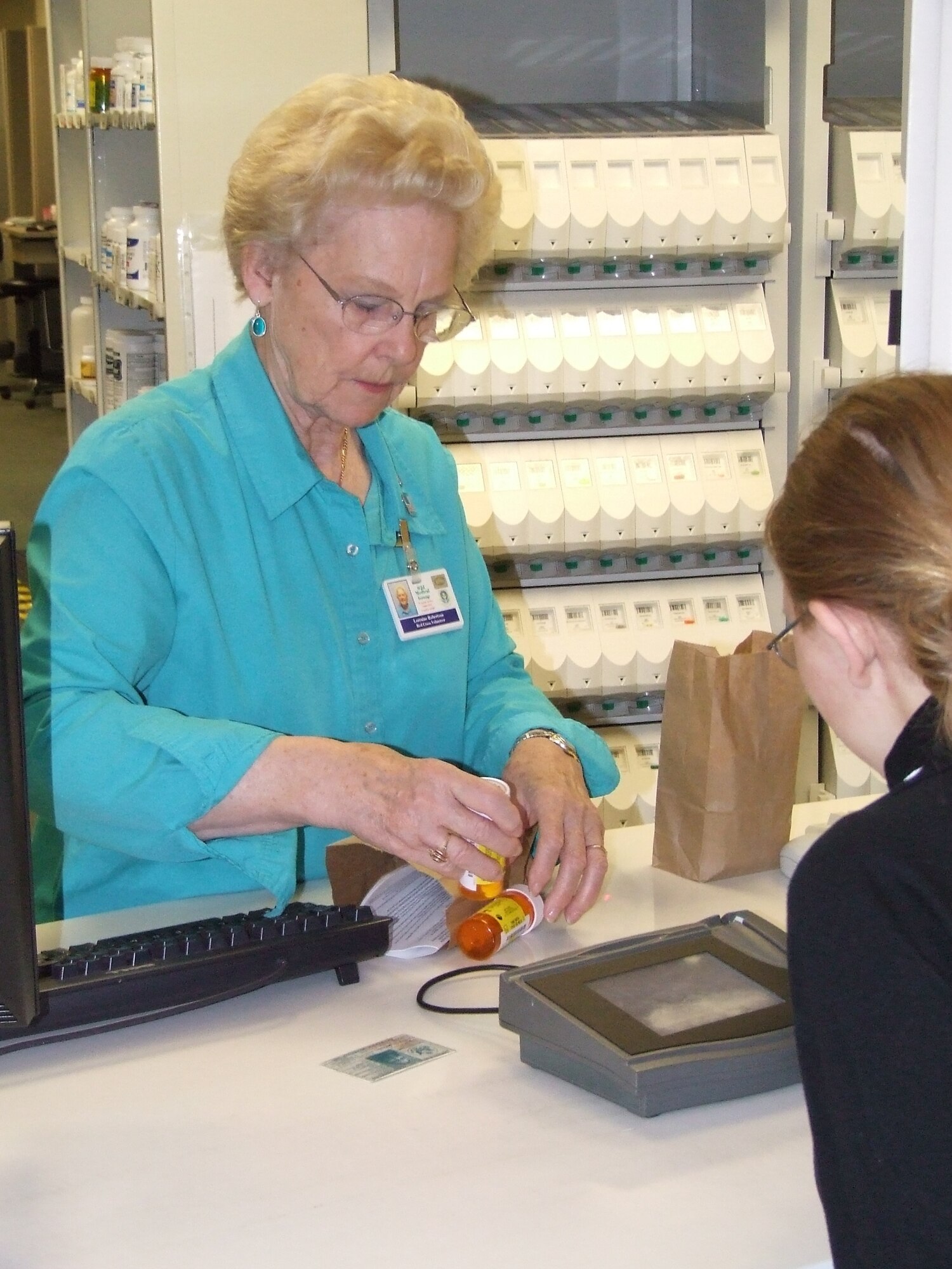 Lorraine Robertson, one of the 62nd Medical Group’s volunteers,
helps a customer get her prescription filled at the clinic’s
pharmacy.