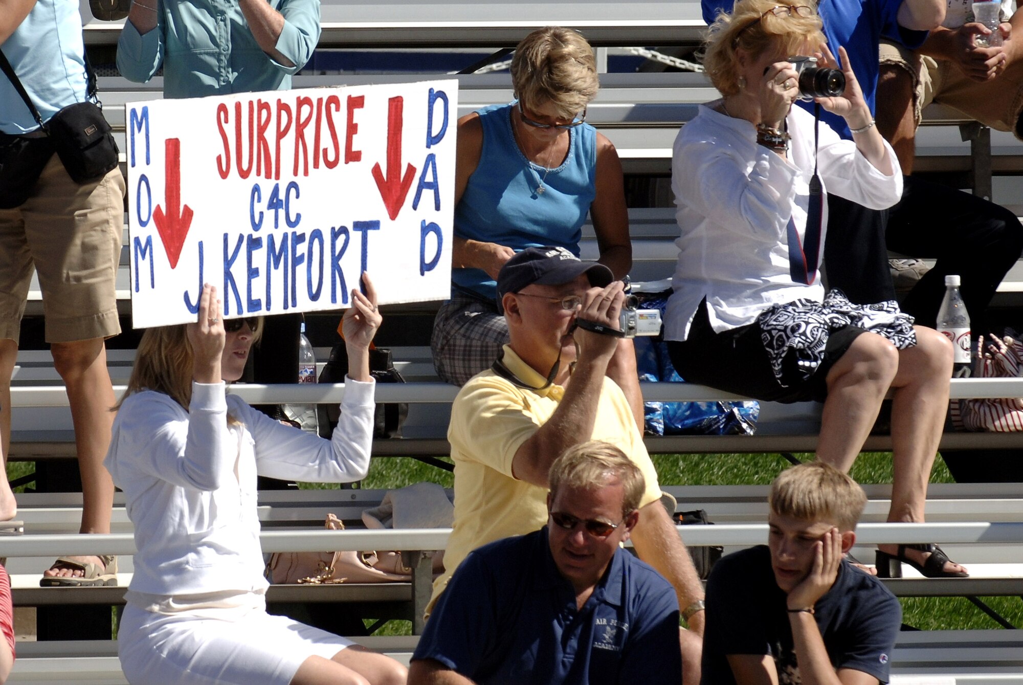 The parents of U.S. Air Force Academy Cadet 4th Class Jordan Kemfort hold up a sign during the Acceptance Parade Aug. 8 at the Academy in Colorado Springs, Colo.  The Acceptance Parade marks the formal acceptance of the new cadets into the cadet wing.  The surprise visit allowed C4C Kemfort to spend 2 hours with his family after the parade.  (U.S. Air Force photo/Mike Kaplan)