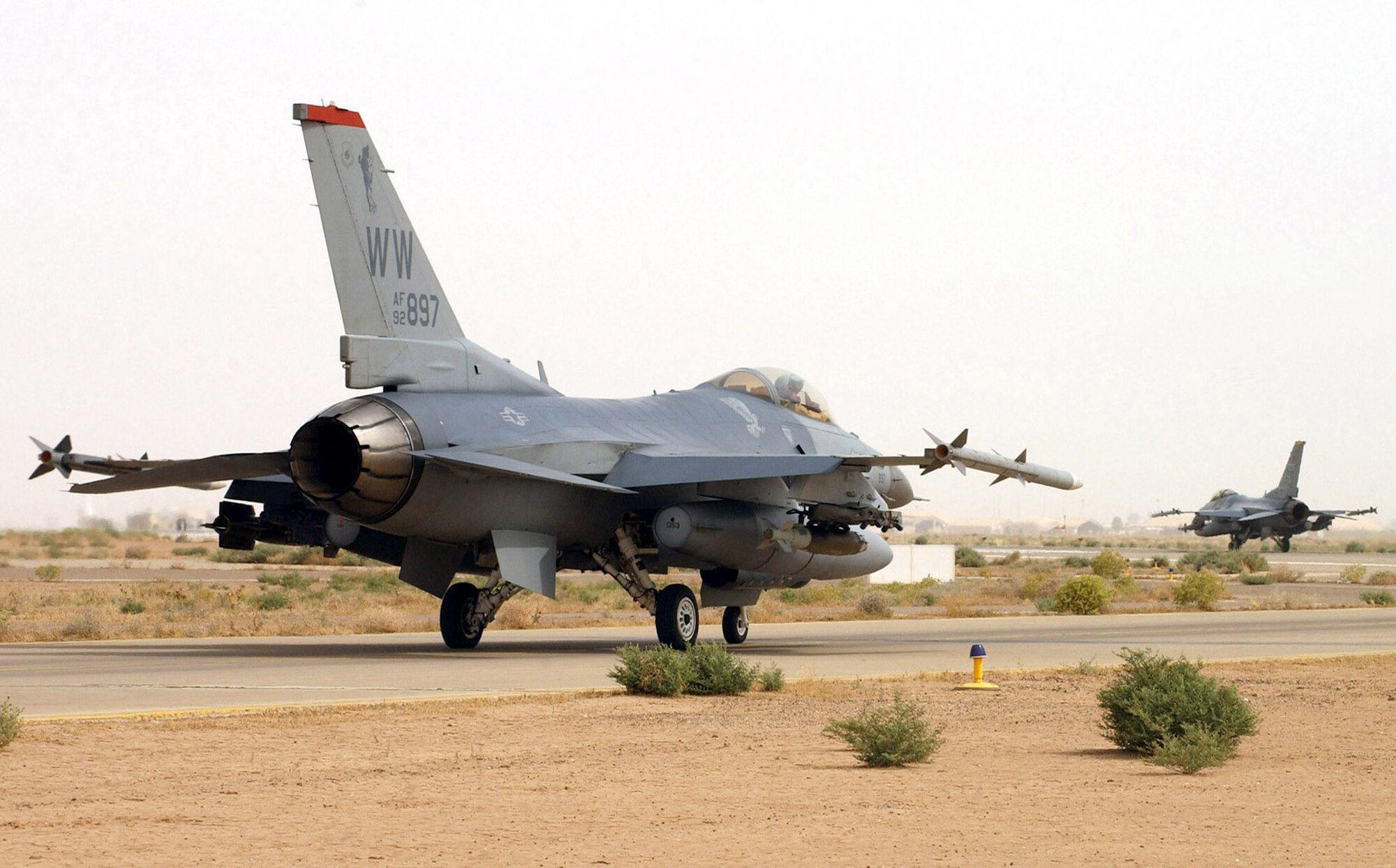 An F-16CJ from the 13th Expeditionary Fighter Squadron at Balad Air Base, Iraq, follows an F-16CJ from its sister squadron, the 14th Expeditionary Fighter Squadron, toward the runway for a combat mission.  (U.S. Air Force photo/1st Lt. Shannon Collins)