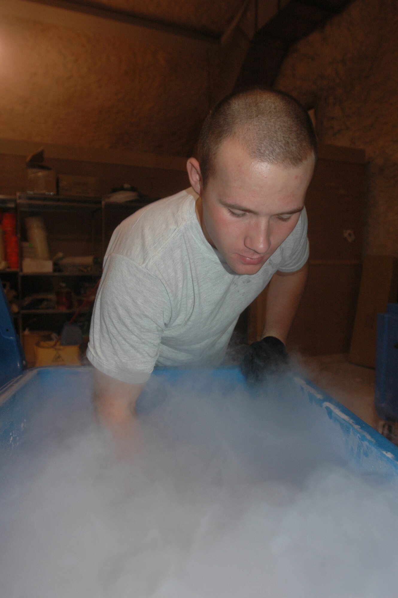 Airman 1st Class David Lavallee, 379th Expeditionary Communications Squadron, scoops a load of dry ice used to keep units of blood components cool while they’re shipped to forward deployed locations.  (U.S. Air Force photo by Senior Airman Clark Staehle)