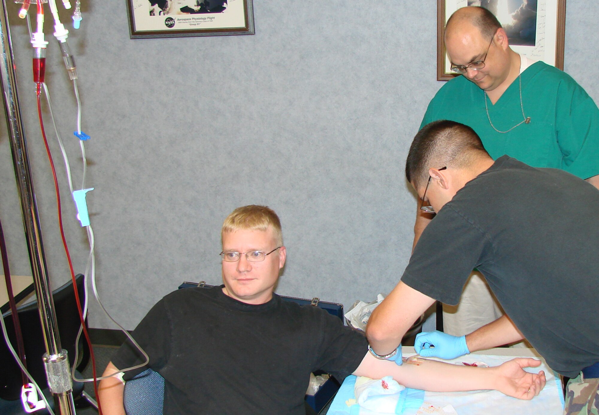 Staff. Sgt. Robert Belus, 71st Comptroller Squadron, left, prepares to start an intervenous line on fellow Combat Lifesaver Class student, Staff Sgt. Richard Dodson, 71st Security Forces Squadron as instructor Richard Shepard, 71st Medical Group Unit training manager observes. The week-long class is designed to train a nonmedical Airman to provide emergency care as a secondary mission. (US Air Force photo/2nd Lt James Justice     