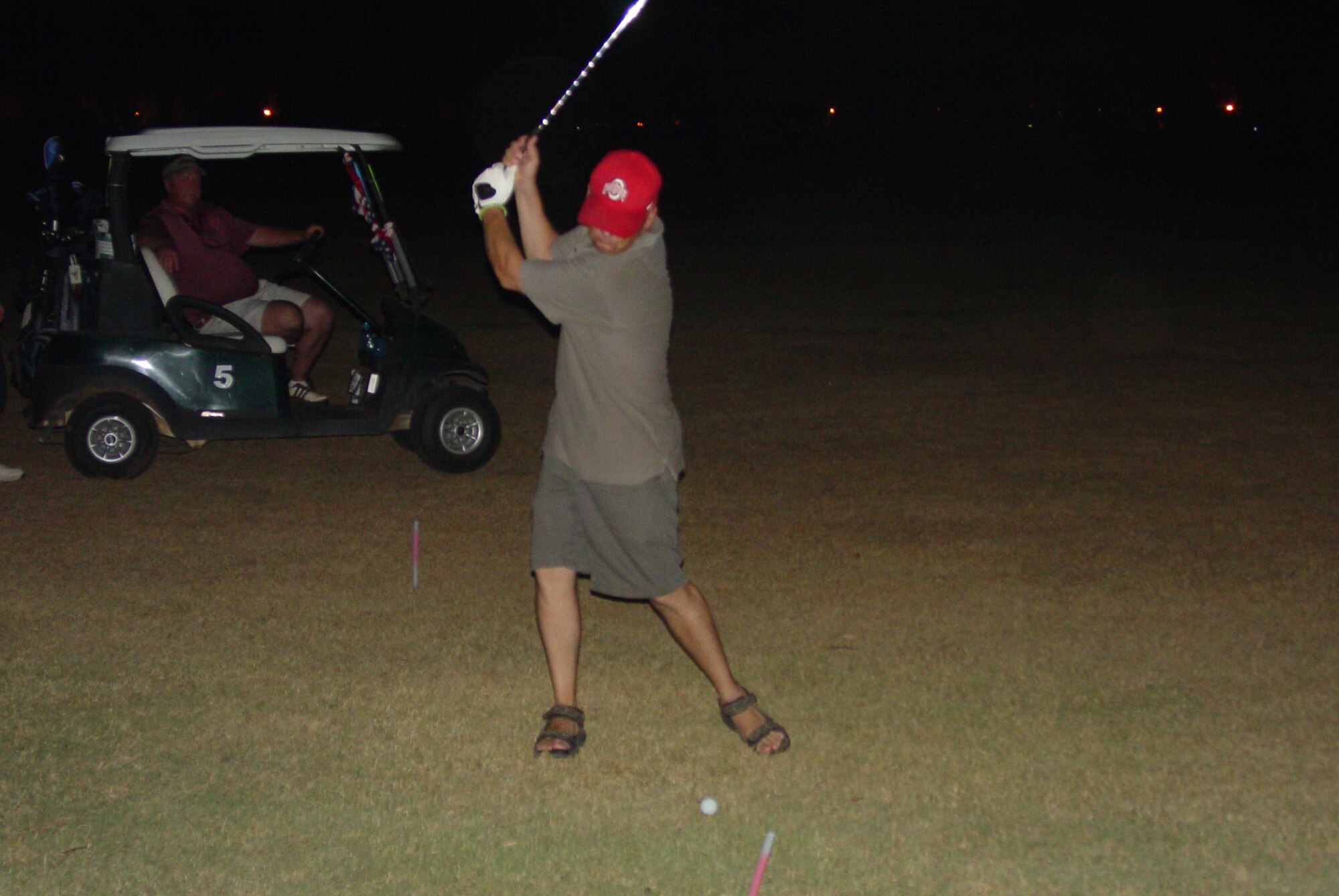 Lt. Col. Chad Butts, 728 Air Mobility Squadron, reaches back to strike the "money" ball while Billy Anderson, 39 Services Squadron, looks on at Hodja Lakes Golf Course July 31. (U. S. Air Force courtesy photo)