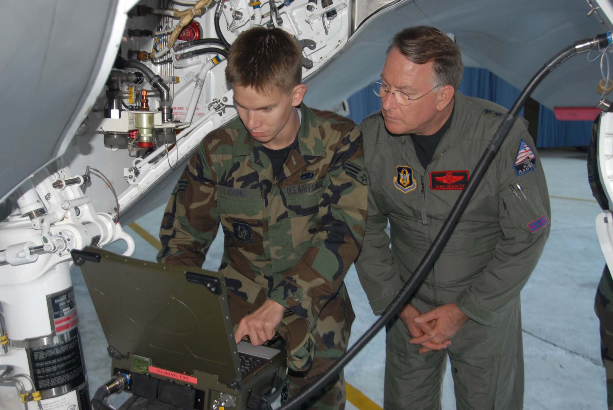 Senior Airman Temujin Ching, 477th Maintenance Squadron crew chief shows Lt. Gen. John A. Bradley, Air Force Reserve Command commander some of the new technology used on the F-22 Raptor following arrival ceremonies at Elmendorf AFB, Alaska. (Air Force photo/Master Sgt. Chance C. Babin)