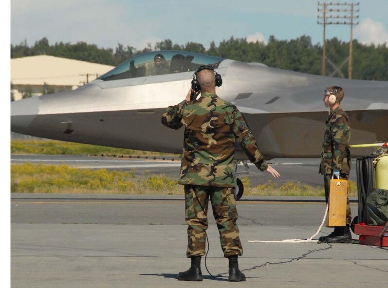 Air Force Reservists Staff Sgt. Derek Welch and Senior Airman Temujin Ching 477th Maintenance Squadron crew chiefs prepare to recieve one of six F-22s to Elmendorf AFB. The Raptor is piloted by Air Force Reserve command pilot Maj. Brian Silkey who flew the aircraft in from Langley AFB, Va. (Air Force photo/Master Sgt. Chance C. Babin)