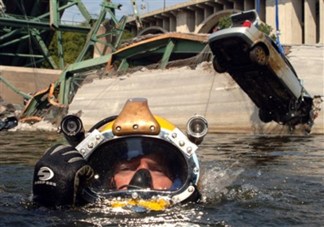 Petty Officer 1st Class Josuha Harsh, Mobile Diving and Salvage Unit 2, surfaces in the Mississippi River as the vehicle he and his team rigged is lifted from the water. 
 