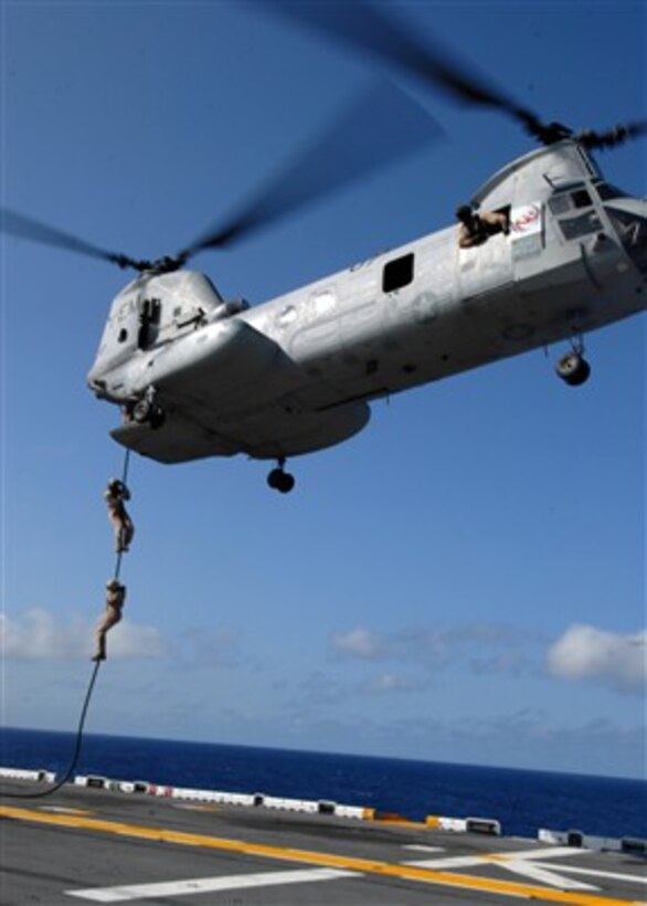 U.S. Marines assigned to Marine Expeditionary Unit 22 slide from a CH-46E Sea Knight helicopter to the flight deck of the amphibious assault ship USS Kearsarge (LHD 3) during a fast rope exercise in the Atlantic Ocean on Aug. 8, 2007.  