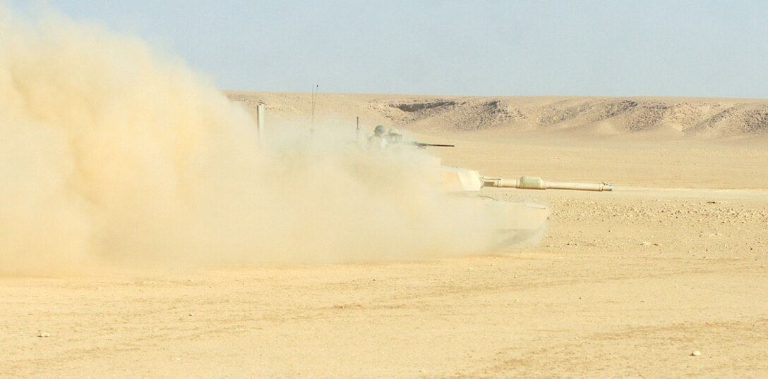 COMBAT OUTPOST RAWAH, IRAQ – A tank with Company B, 1st Tank Battalion, supporting Task Force Highlander, Regimental Combat Team 2, speeds across the Iraqi desert and bursts from a dust cloud. The tanks spent nearly a week combing the Iraqi desert in support of Operation Punisher III. Official Marine Corps Photo By Cpl. Ryan C. Heiser.