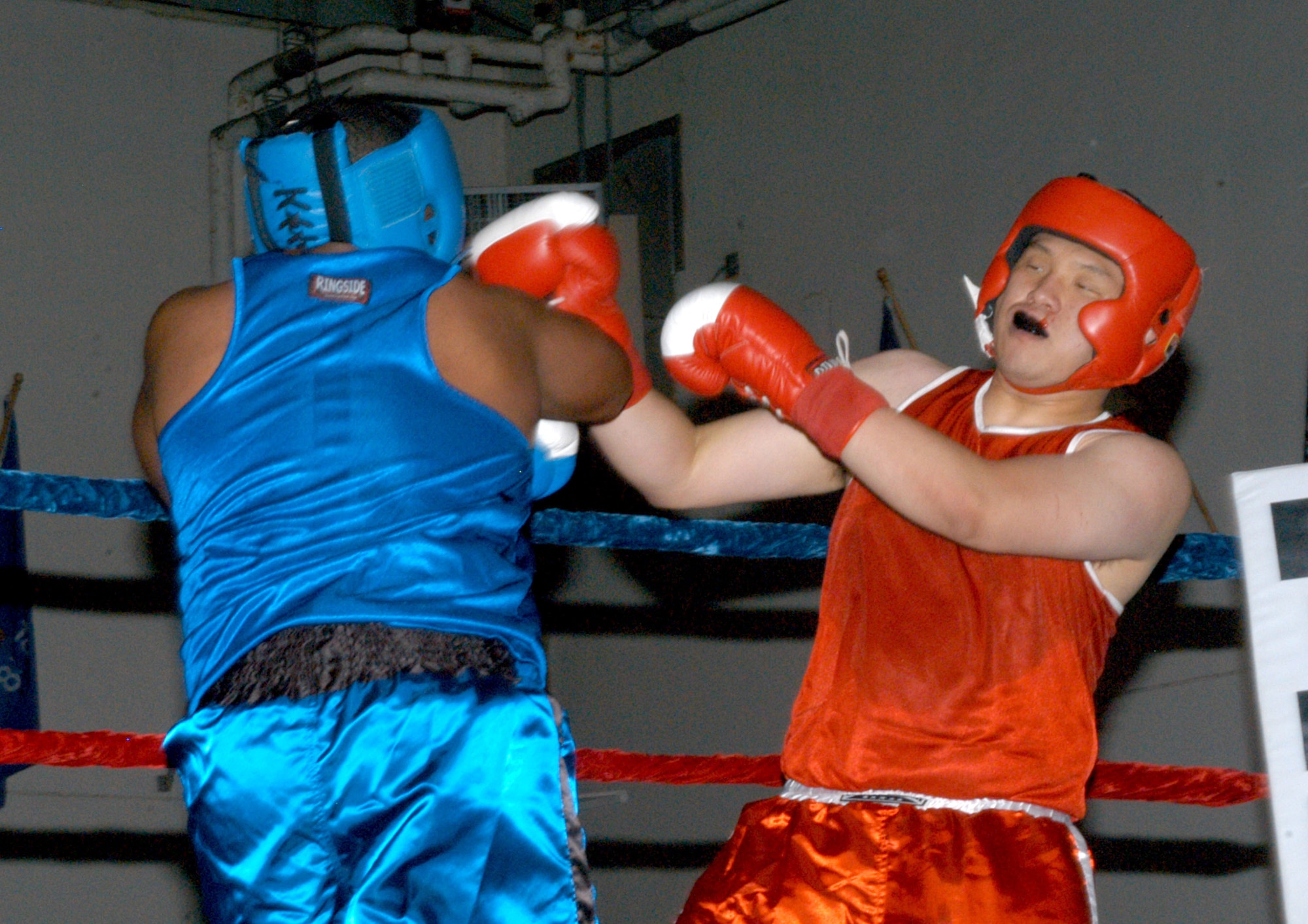 U.S. ARMY GARRISON HUMPHREYS, South Korea - Won-Tae Kim, stationed here, ducks and sways to miss a punch thrown by Kunsan Air Base's Justice Burrus during the 2007 summer Smoker Boxing Tournament Aug. 11 here. This was the 18th bout of the event, but was the first fight featuring a 'KATUSA' ROK Army Soldier and their U.S. counterpart here to date. (U.S. Air Force photo/Staff Sgt. Darcie Ibidapo)