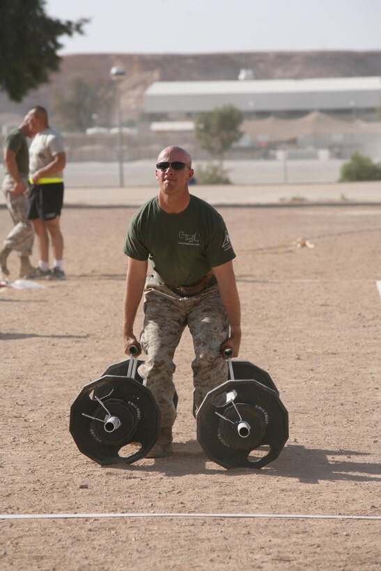 Sgt. Thomas Buhls of 2nd Low Altitude Air Defense Battalion, puts everything he has into making it across the finish line during the Farmer?s Carry event of the Al Asad Strongman Competition, Aug. 12. During the Farmer?s Carry, the 175 and under competitors had to carry 170 pounds in each arm.