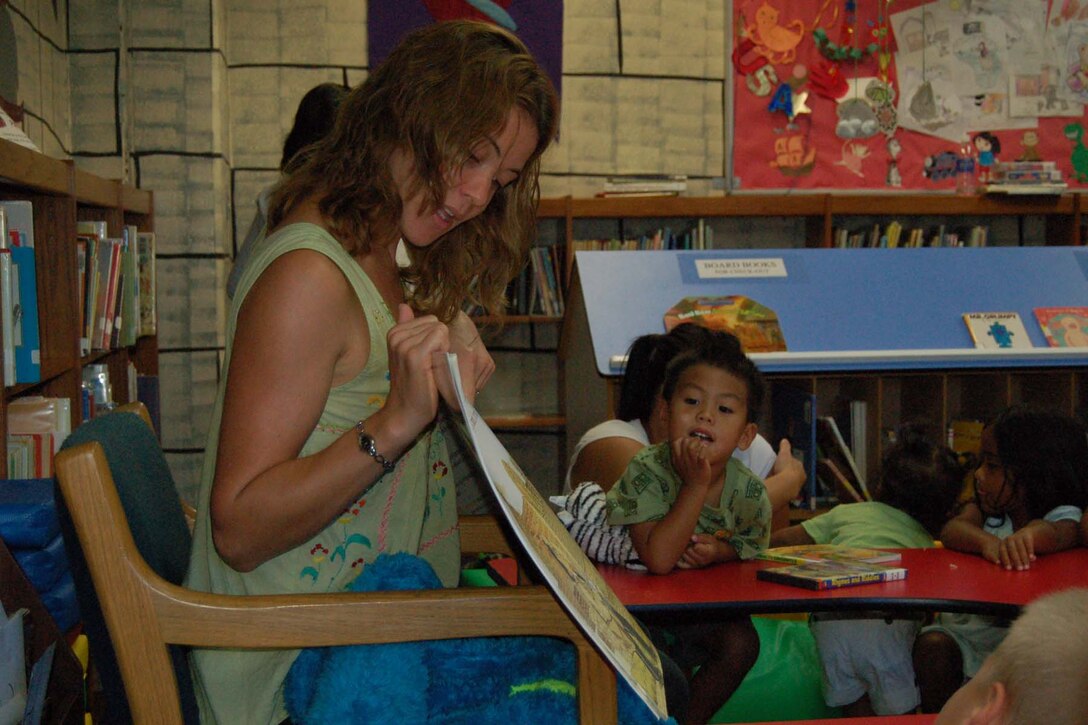 ANDERSEN AIR FORCE BASE, Guam - Emilie Fidler, a library aide for the 36th Services Squadron, reads "The Wind Blew" by Pat Hutchins to children attending Story Time at the base library July 25.  Story Time is held every Wednesday at 10:30 a.m. and at 3 p.m.  The activity is designed to encourage children to participate in reading.  (U.S. Air Force photo by Airman 1st Class Carissa Morgan/ 36th Wing Public Affairs)
