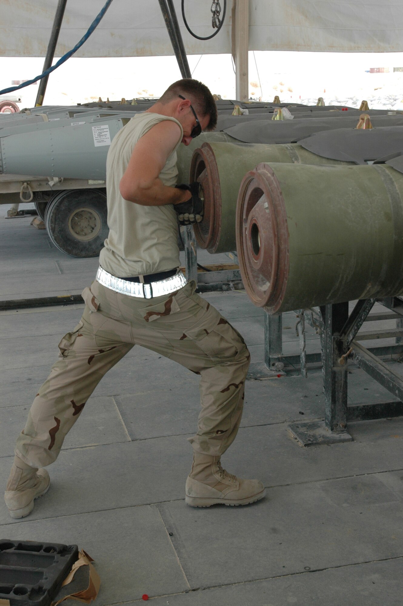 Senior Airman John Neufield, 379th Expeditionary Maintenance Squadron, ammo flight, torques a fuze-retaining ring on a bomb. (U.S. Air Force photo by Capt. Teresa Sullivan)