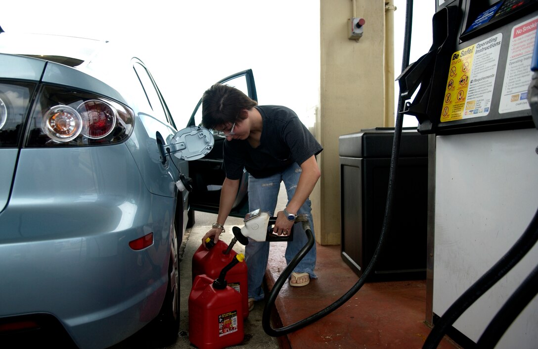 ANDERSEN AIR FORCE BASE, Guam - Rossela, wife of Staff Sgt. Daniel Flick, 36th Civil Engineering Squadron, fills up containers with gas in preparation for typhoon Kong-Ray, April 1, 2007.  The 36th Wing personnel take appropriate actions and make necessary provisions in preparation for every typhoon that has the potential strike Andersen. (Air Force photo by Senior Airman Miranda Moorer)