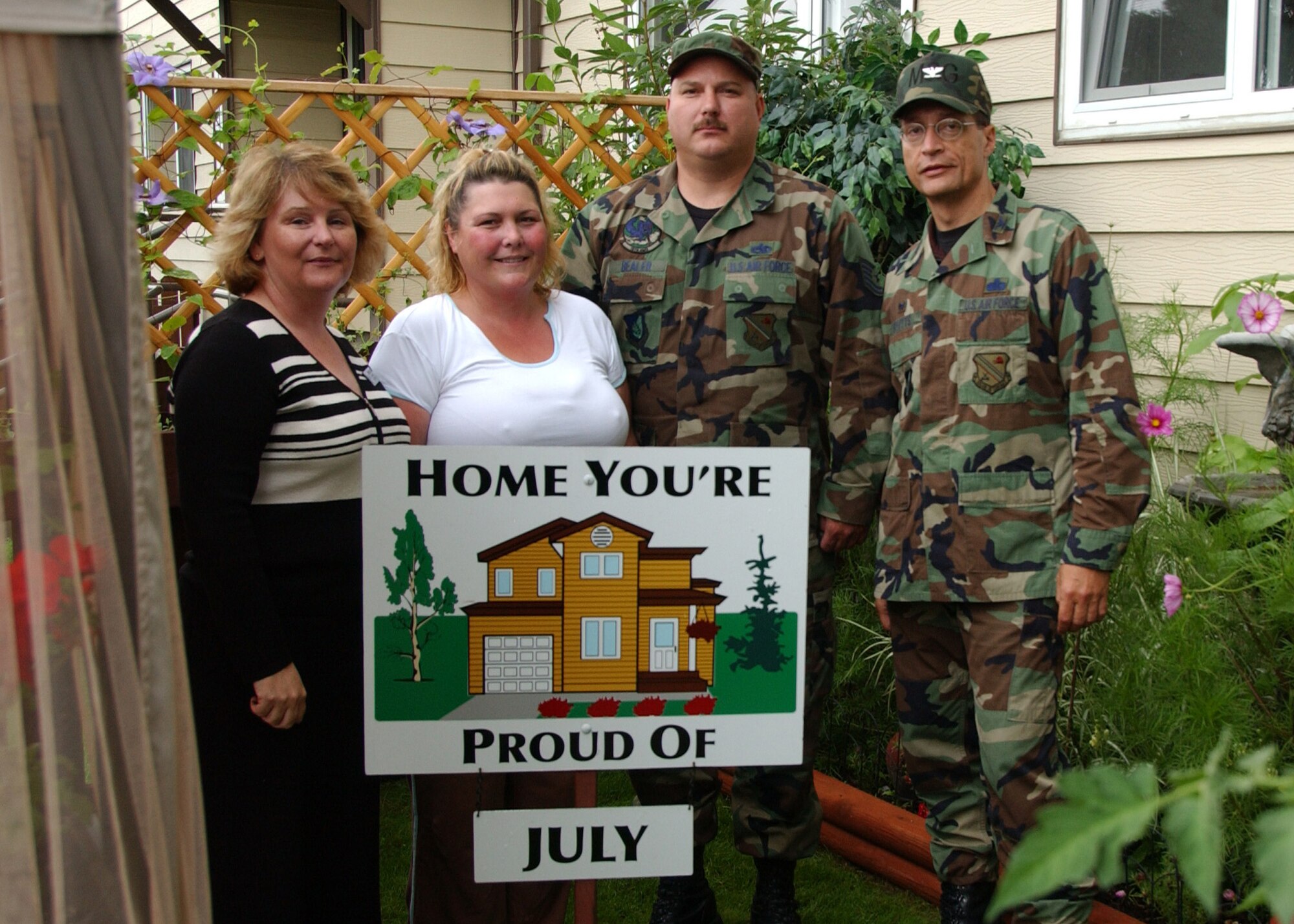 EIELSON AIR FORCE BASE, Alaska--Tech. Sgt. Richard Bealer, 354th Aircraft Maintenance Squadron, and wife Rachelle, pose with Lorie Dallas, 354th Civil Engineer Squadron military family housing, and Col. John Stutts, 354th Mission Support Group commander, for winning the July Home You're Proud Of for Area 3. Each home to win received $75 in gift certificates from agencies on and off base. Not available for a photo was Tech. Sgt. Sheryl Baker, 354th Force Support Squadron, who won HYPO for Area 1. (U.S. Air Force photo by Airman 1st Class Christopher Griffin)                      