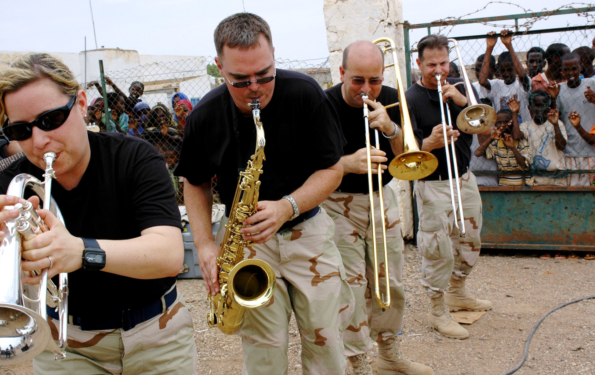 (From left) Tech. Sgt. Shonda Winkler, Senior Master Sgt. Mark Bruehl, Capt. Jeffery Matthews and Senior Master Sgt. John Cornachionne, members of the U.S. Central Command Air Forces band "Thunder Roll," play to a crowd in the village of Hol Hol, Djibouti, during their Africa tour. Thunder Roll tours approximately 80 days out of the year to expeditionary locations around the world. (U.S. Army photo/Sgt. Brandon McCarty)
