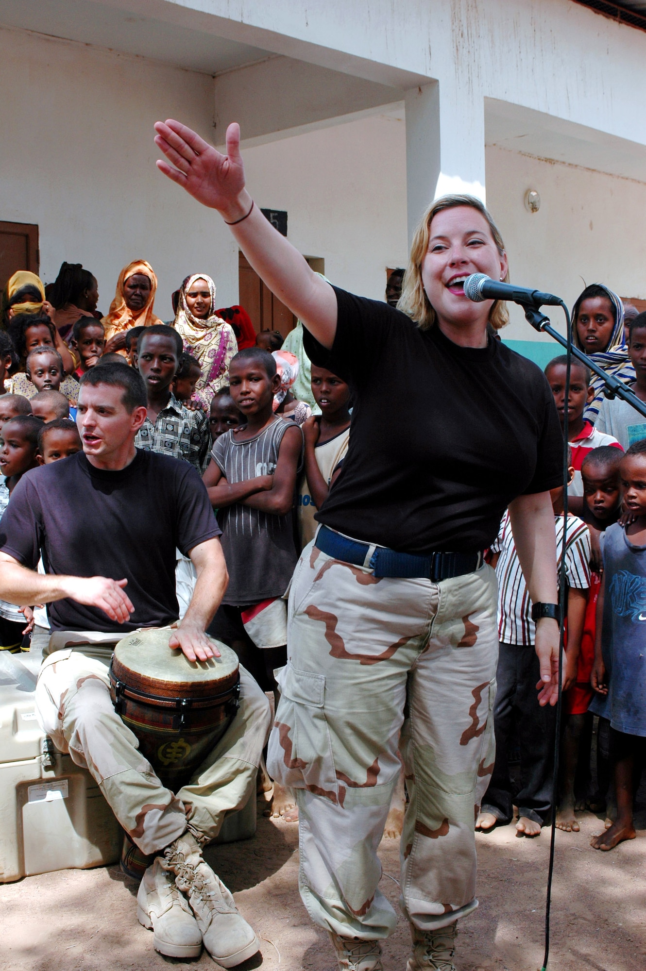 U.S. Central Command Air Forces band members Tech. Sgt. Shonda Winkler and Staff Sgt. James Doyle of "Thunder Roll" play to a crowd of Djiboutians Aug. 10 in the village of Danerjog during their Africa tour. Thunder Roll tours approximately 80 days out of the year to expeditionary locations around the world. (U.S. Army photo/Sgt. Brandon McCarty) 