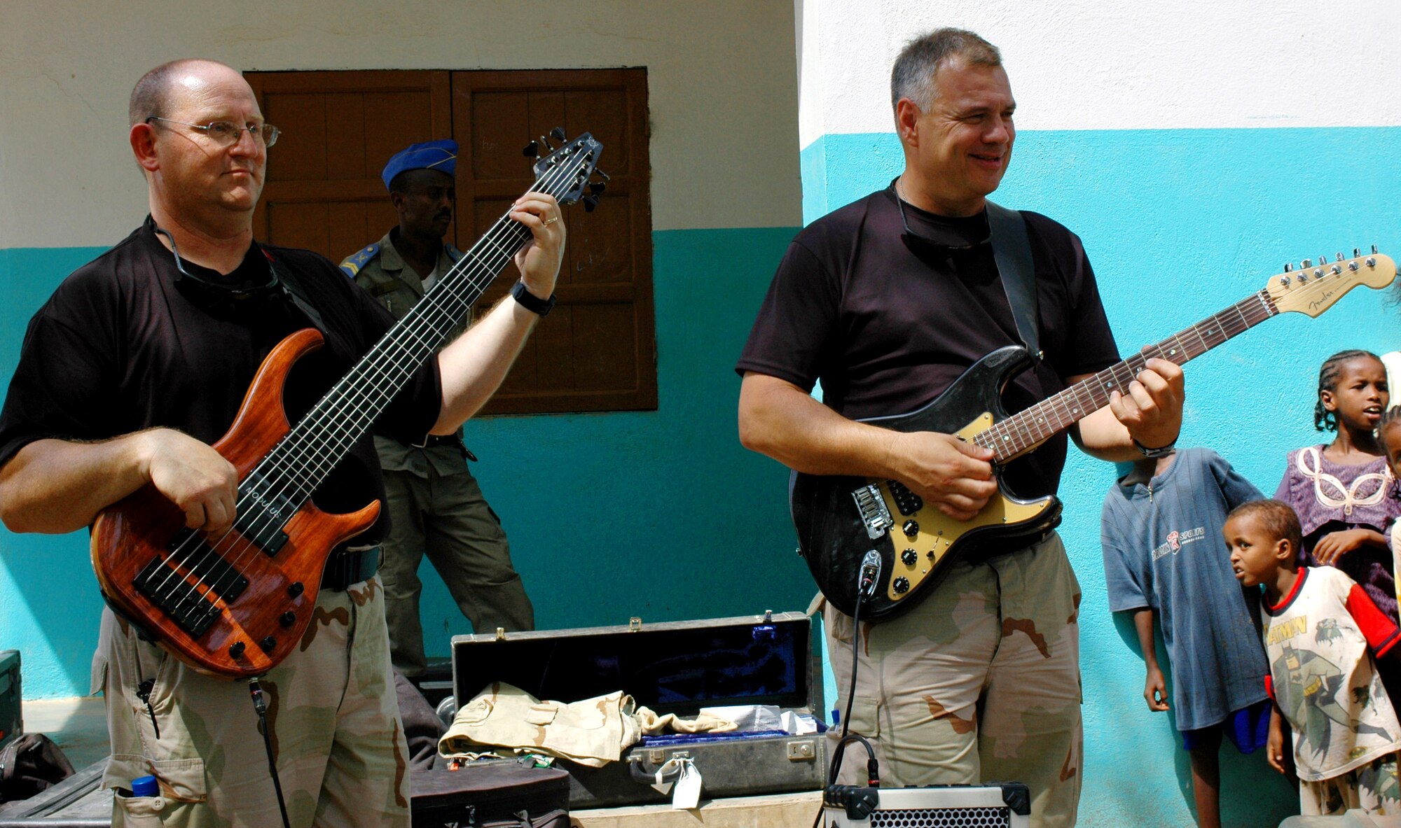 Master Sgt. August Wenck and Staff Sgt. Randy Roberson play to a crowd of Djiboutians Aug. 10 in the village of Danerjog during their Africa tour. The NCOs are members of the U.S. Central Command Air Forces band, "Thunder Roll." The band tours approximately 80 days a year to worldwide expeditionary locations. (U.S. Army photo/Sgt. Brandon McCarty) 