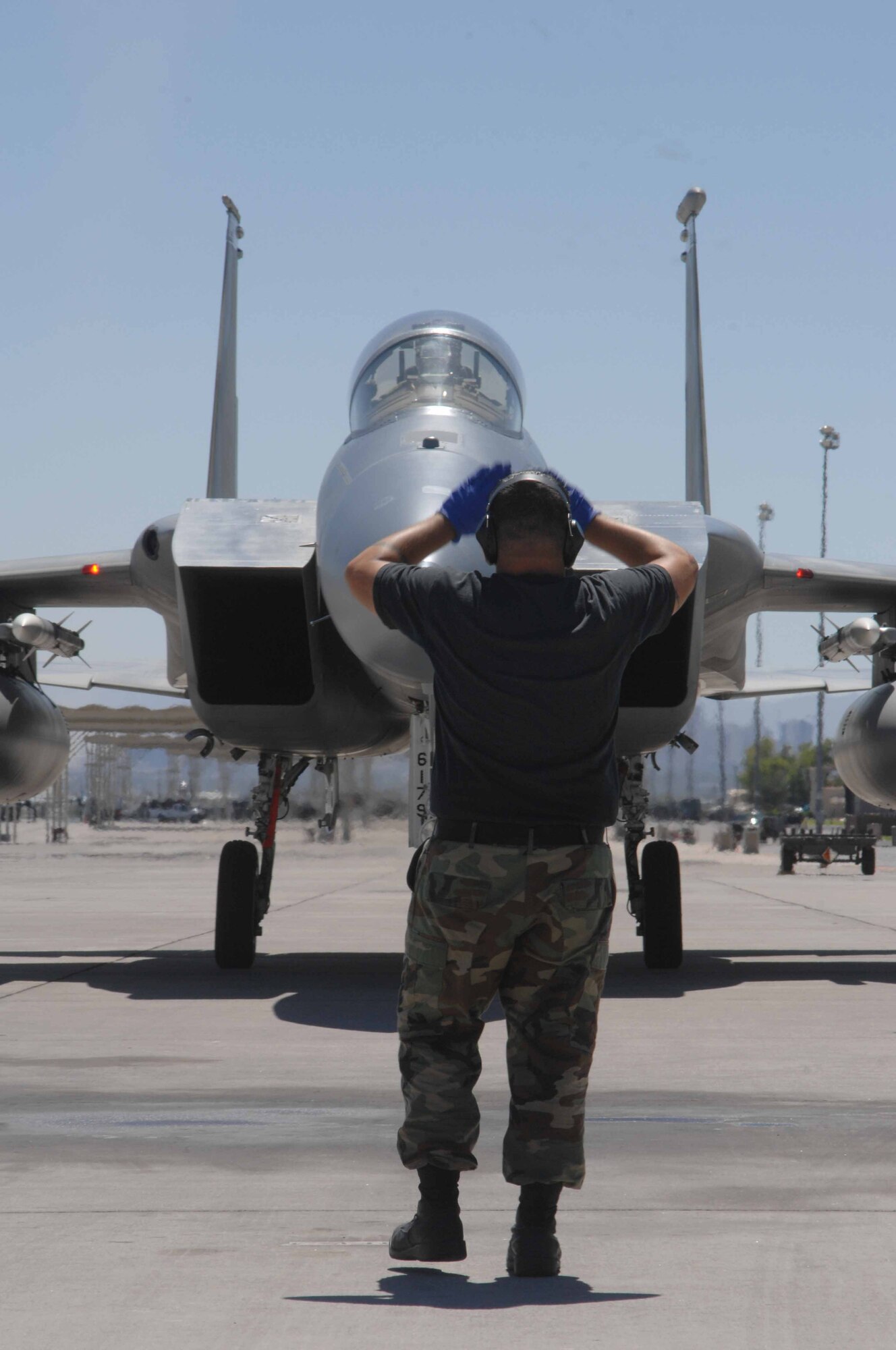 MOUNTAIN HOME AIR FORCE BASE, Idaho -- Senior Airman Dejay Ort, 390th Fighter Squadron crew chief, marshals a jet after a training mission Aug. 10 at Nellis Air Force Base, Nev. The Wild Boars provided support for the United States Air Force Weapons School by flying air-to-air missions as simulated enemy aircraft July 23 through Aug. 18. (U.S. Air Force Photo/Senior Airman Larry E. Reid Jr.)