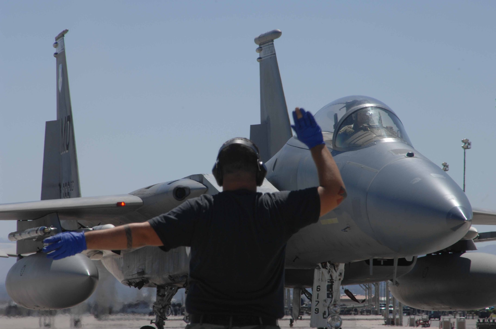 MOUNTAIN HOME AIR FORCE BASE, Idaho -- Senior Airman Dejay Ort, 390th Fighter Squadron crew chief, marshals a jet after a training mission Aug. 10 at Nellis Air Force Base, Nev. The Wild Boars provided support for the United States Air Force Weapons School by flying air-to-air missions as simulated enemy aircraft July 23 through Aug. 18. (U.S. Air Force Photo/Senior Airman Larry E. Reid Jr.)