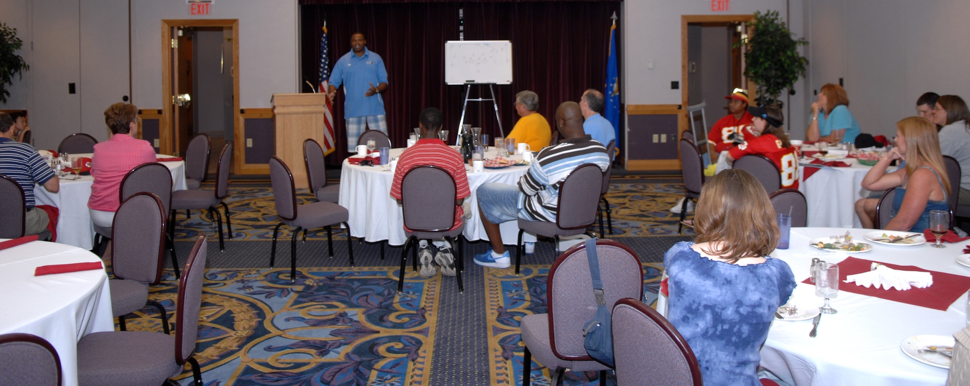 WHITEMAN AIR FORCE BASE, Mo. – Team Whiteman members look on as Neil Smith talks about football during the Football Widow’s Luncheon at Missions End Aug. 8. The mission of the luncheon was to provide knowledge and understanding about football to those who feel left out on game day. (U.S. Air Force Photo/Airman 1st Class Stephen Linch)