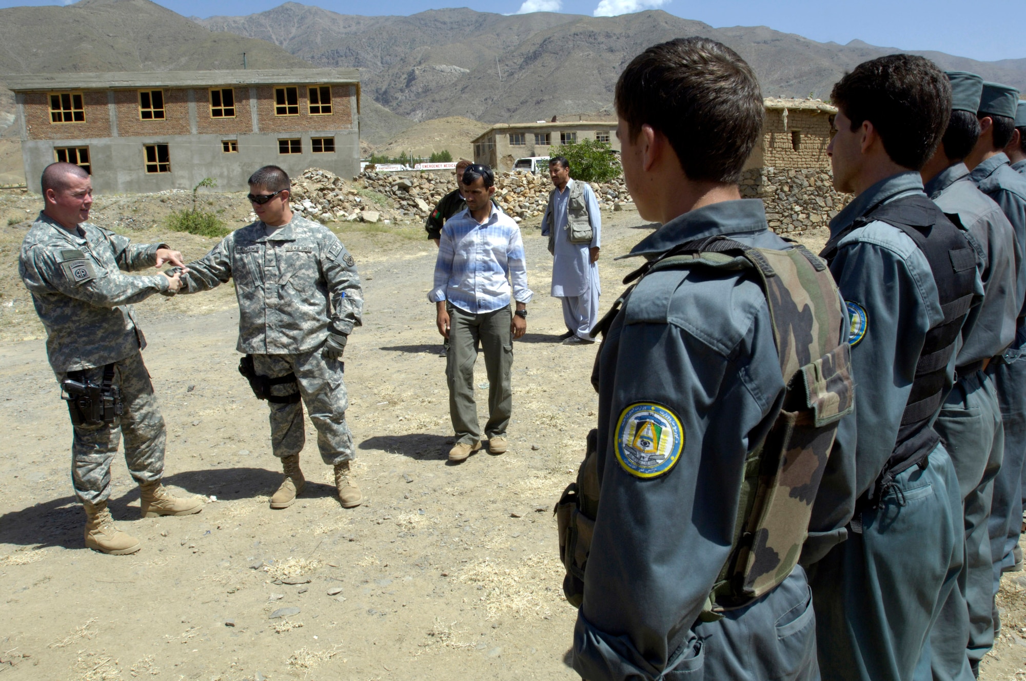 Tech. Sgt. Michael Downey (left) and Staff Sgt. Andre Sanchez-Romero demonstrate how to escape from a wrist lock to members of the Afghan National Police Aug. 6. The security forces Airmen, members of the Panjshir Provincial Reconstruction Team, traveled with other PRT members to the Anaba district of Panjshir Province, Afghanistan, to provide training to the ANP working in the district. Sergeant Downey is deployed from the Pentagon, Washington, D.C. Sergeant Sanchez-Romero is deployed from Minot Air Force Base, N.D.  (U.S. Air Force photo/Master Sgt. Jim Varhegyi)