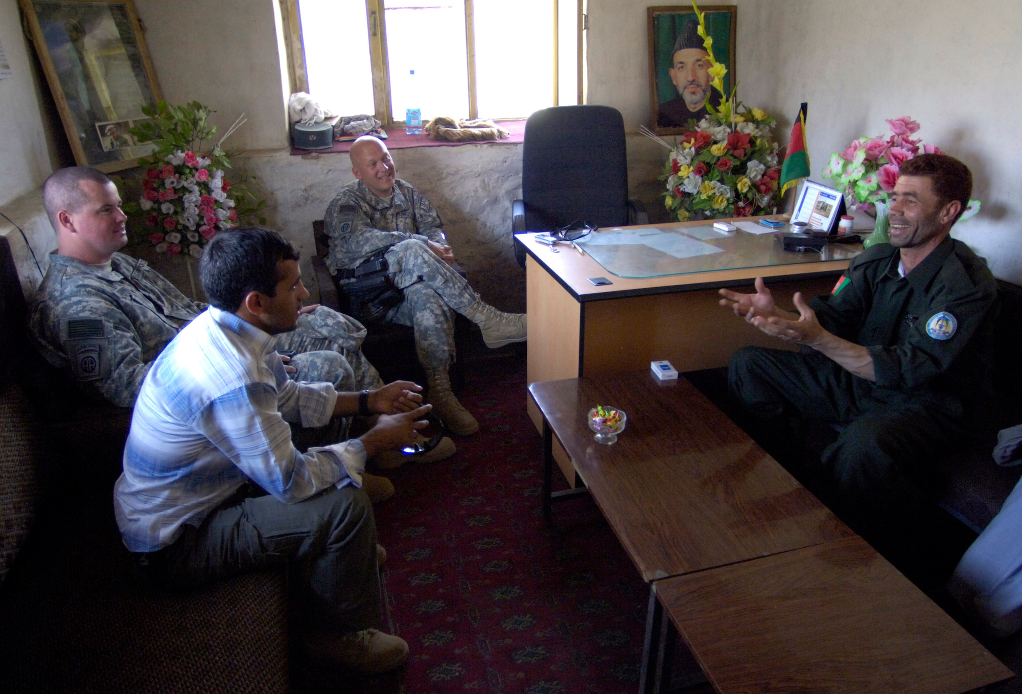 Panjshir Provincial Reconstruction Team commander Lt. Col. Christopher Luedtke (center) and Tech. Sgt. Michael Downey visit with Anaba district police chief Zardot Towhidi (right) and an interpreter Aug. 6. Colonel Luedtke brought members of his PRT to the Anaba district of Panjshir province, Afghanistan, to provide training to Afghan National Police serving in the area. Colonel Luedtke is deployed from Hill Air Force Base, Utah. Sergeant Downey is a security forces craftsman deployed from the Pentagon, Washington, D.C. (U.S. Air Force photo/Master Sgt. Jim Varhegyi)