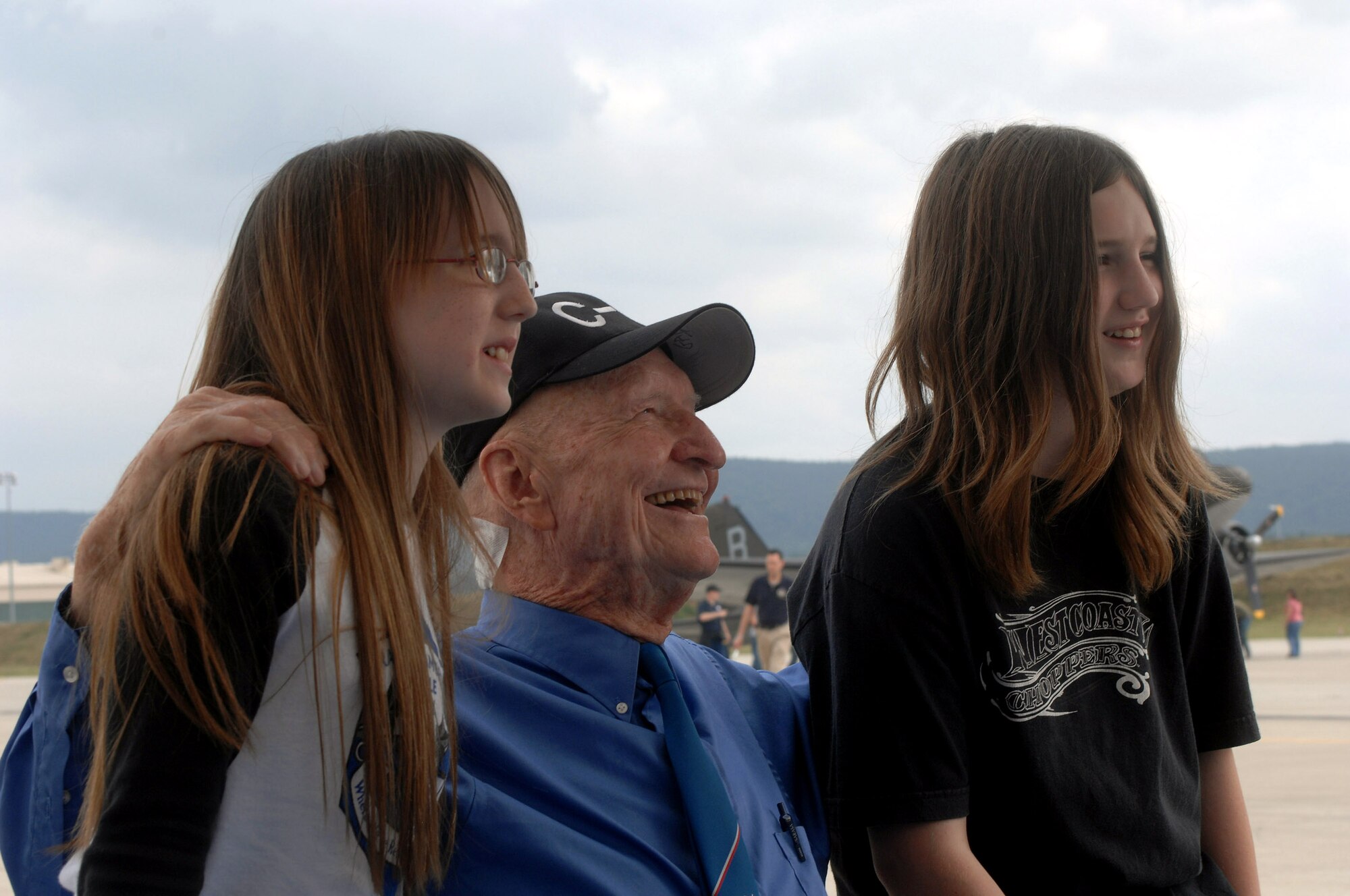 Retired Col. Gail Halvorsen, the Berlin Candy Bomber, takes a break from signing autographs for a photo opportunity with Natasha and Alex Harris during U.S. Air Forces in Europe's Air Force 60th Anniversary celebration at Ramstein Air Base, Germany, Aug. 11. (U.S. Air Force photo/Airman 1st Class Kenny Holston) 