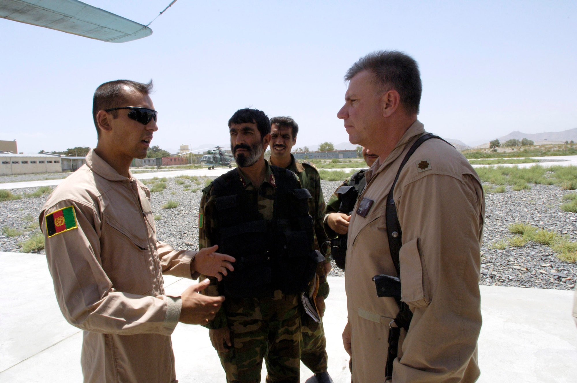 U.S. Air Force mentor Maj. Mark Campbell (right) talks with cadet Faiz Mohd Ramaki (left)from the Afghan National Army Air Corps before a mission July 25 at Kabul International Airport, Afghanistan. Cadet Ramaki serves as a translator and was recently selected to be the first ANA Air Corps member to attend Air Force pilot training in the United States. (U.S. Air Force photo/Master Sgt. Jim Varhegyi)