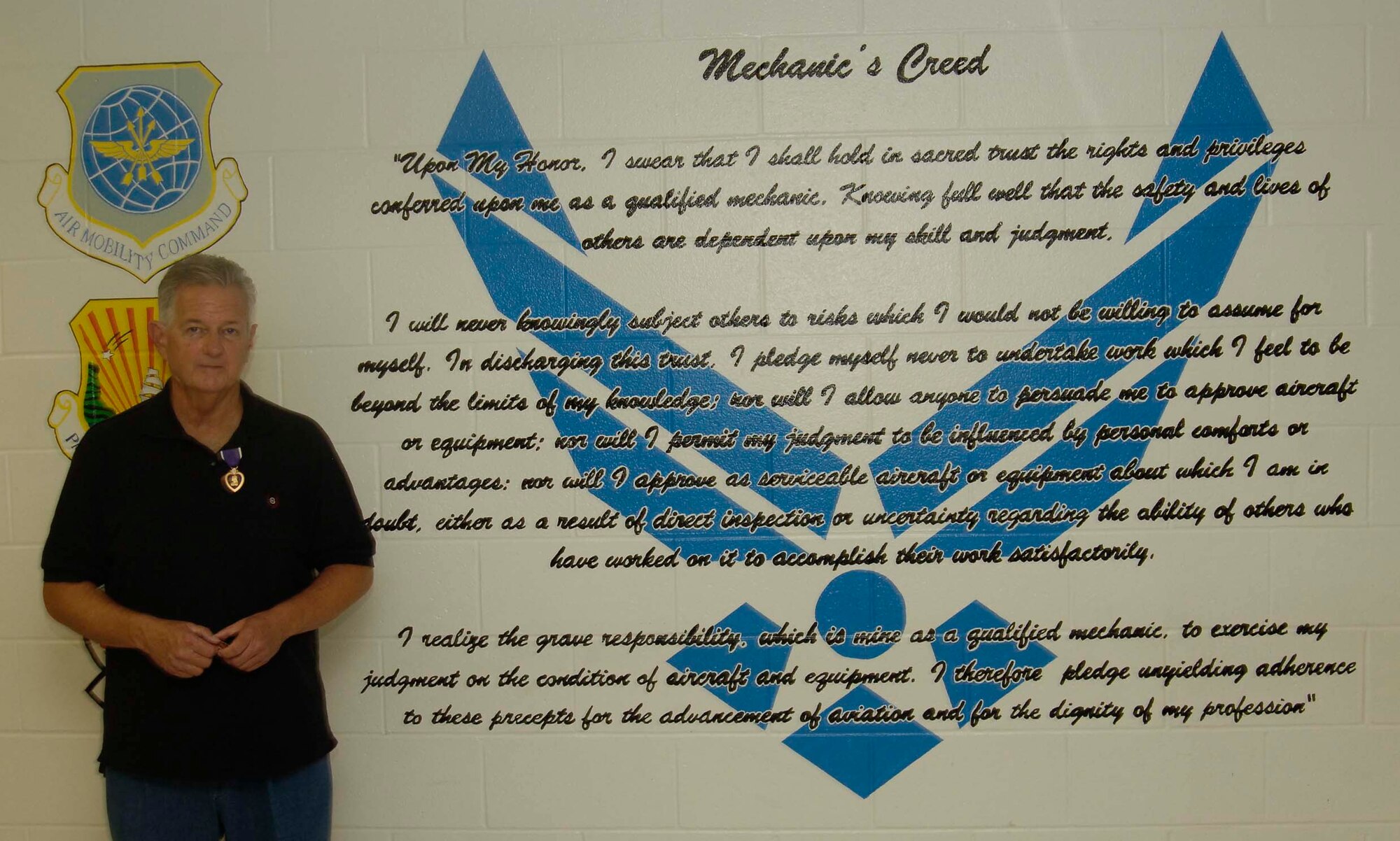 Wayne Sufficool, former MacDill Air Force Base crew chief and Vietnam Veteran, stands next to the Mechanics Creed posted on the wall in a 6th Maintenance Group building where he received his Purple Heart Decoration after more than 39 years Aug. 9, 2007. Mr. Sufficool was awarded the decoration for the wounds he suffered while stationed in Tan Son Nhut Air Force Base, Republic of Vietnam, in February 1968. (Air Force Photo by Senior Airman David Minor)