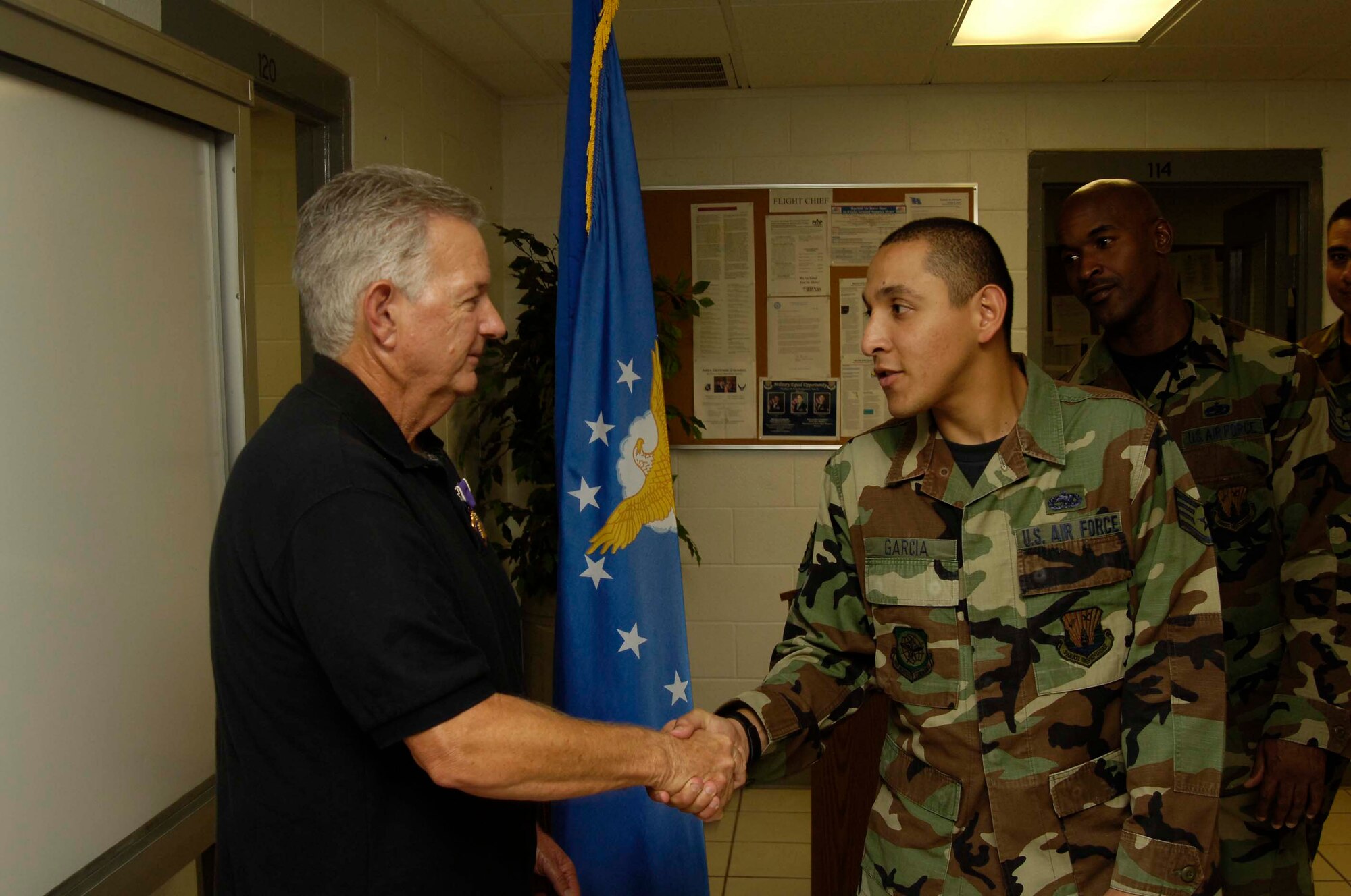 Wayne Sufficool, former MacDill Air Force Base crew chief and Vietnam Veteran, shakes hands with Staff Sgt. Ariel Garcia, 6th Aircraft Maintenance Squadron resource advisor, after receiving the Purple Heart Decoration in a ceremony here Aug. 9, 2007. Mr. Sufficool was awarded the decoration for the wounds he suffered while stationed in Tan Son Nhut Air Force Base, Republic of Vietnam, in February 1968. (Air Force Photo by Senior Airman David Minor) 