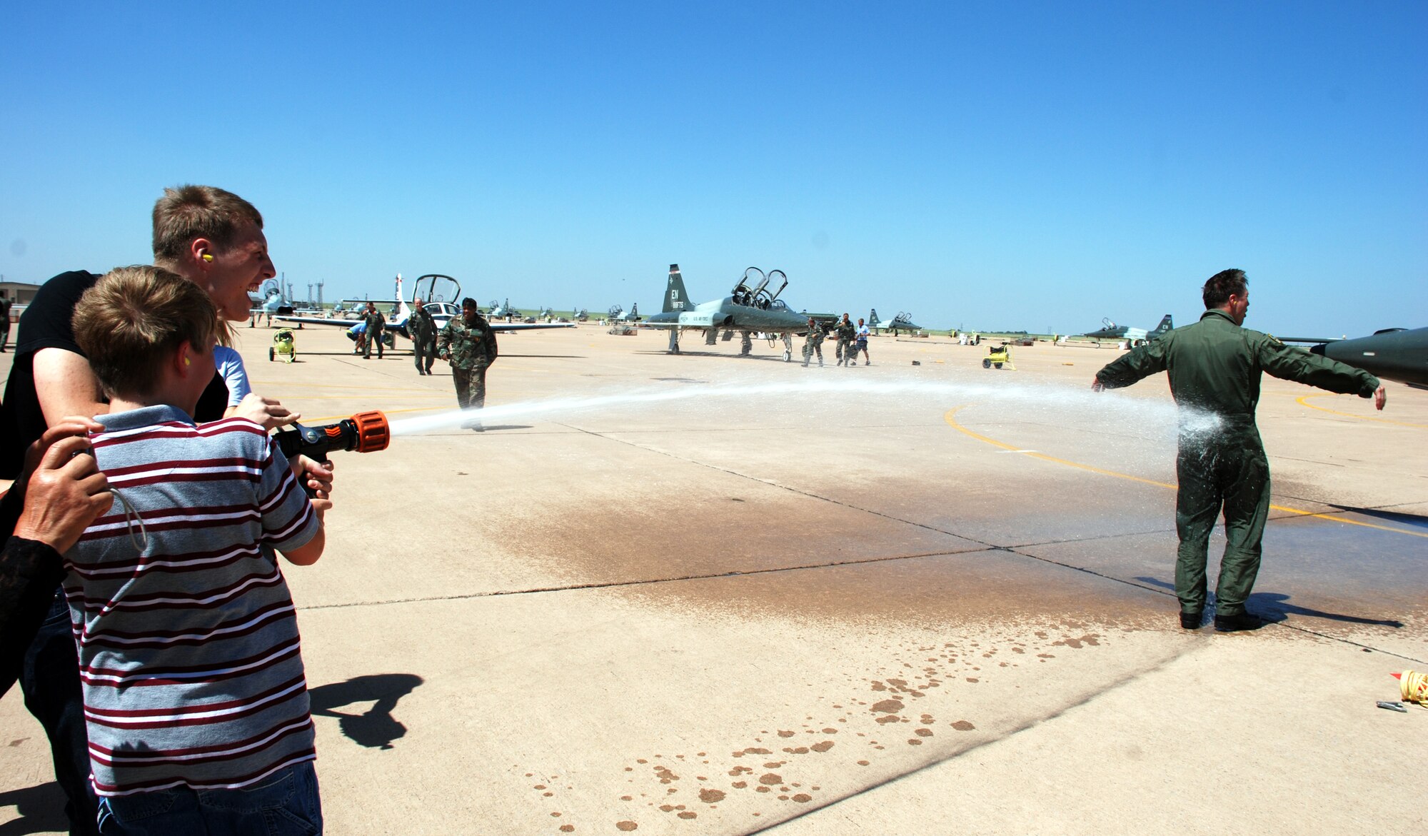 Col. Jeffrey Kendall, 80th Flying Training Wing commander, gets soaked by his sons Neil and Jacob after his fini-flight Aug. 9. (U.S. Air Force photo/Airman 1st Class Jacob Corbin)